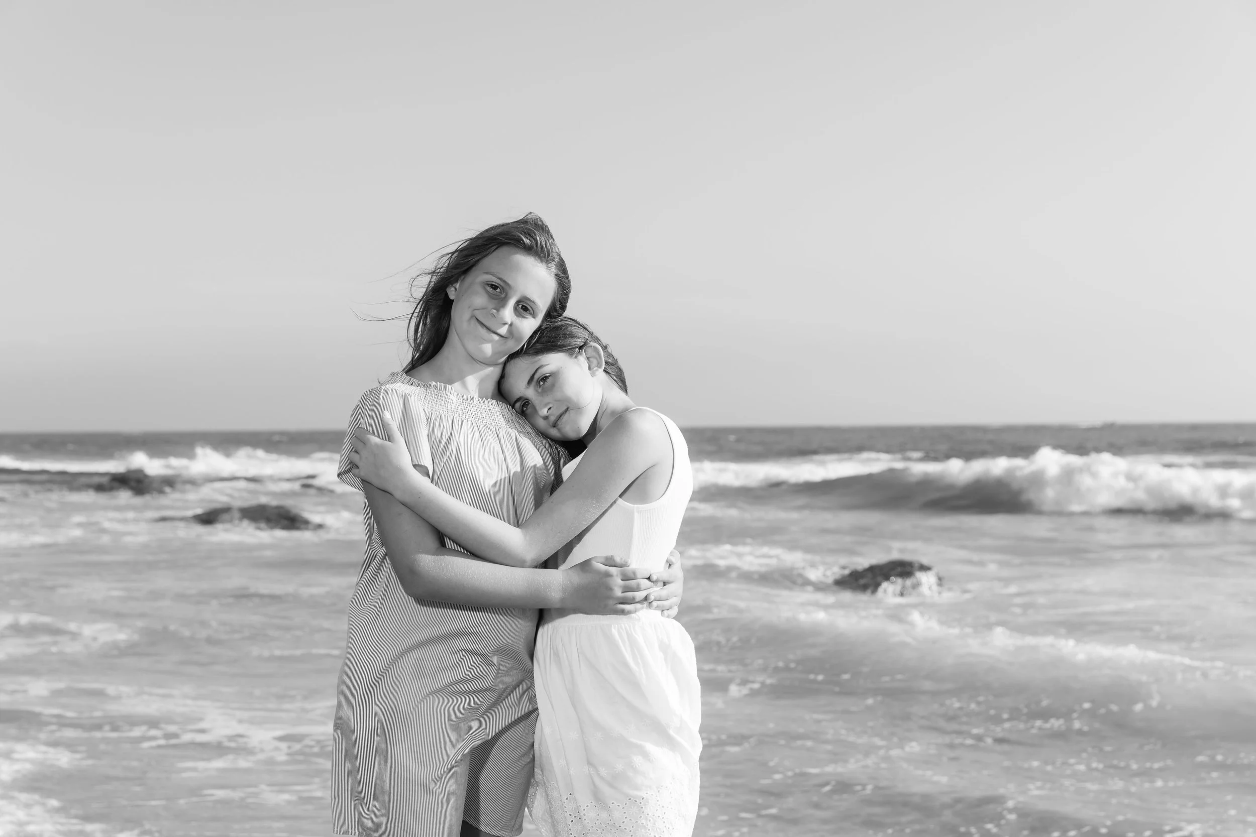kid siblings hugging on the beach in newport crystal cove.jpg