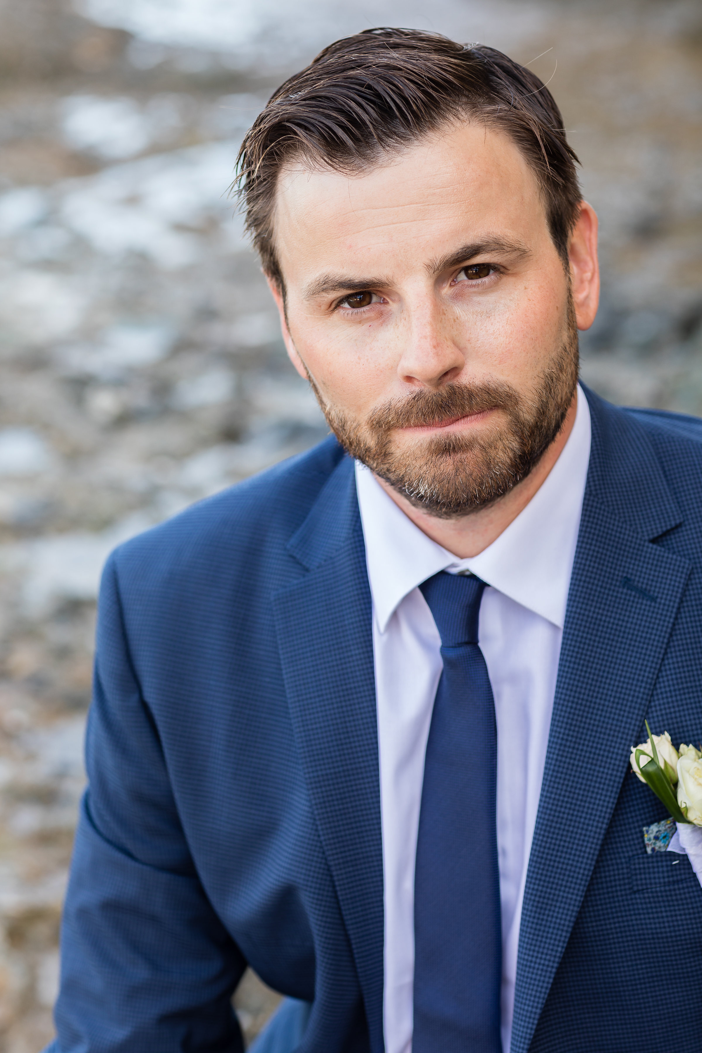Photo of Handsome Wedding Groom in blue suit with facial hair on the rocky Laguna Beach shores.jpg