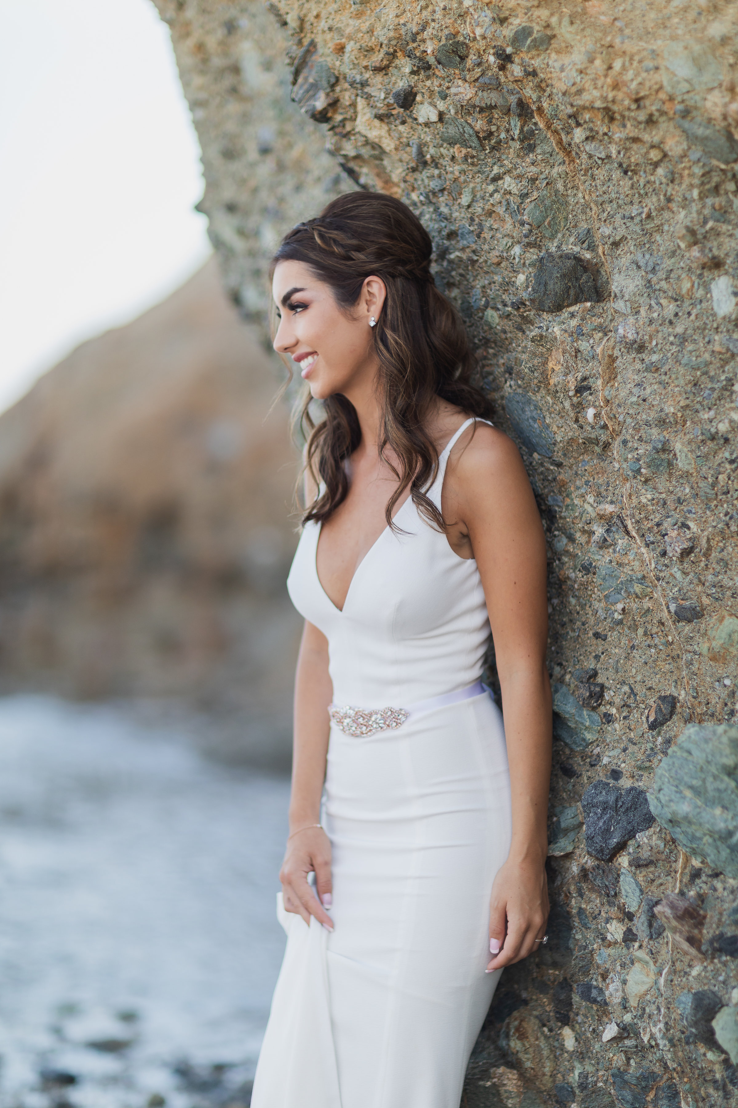 Photo of Beautiful Bride in a simple white wedding form fitting dress on the rocky beach.jpg