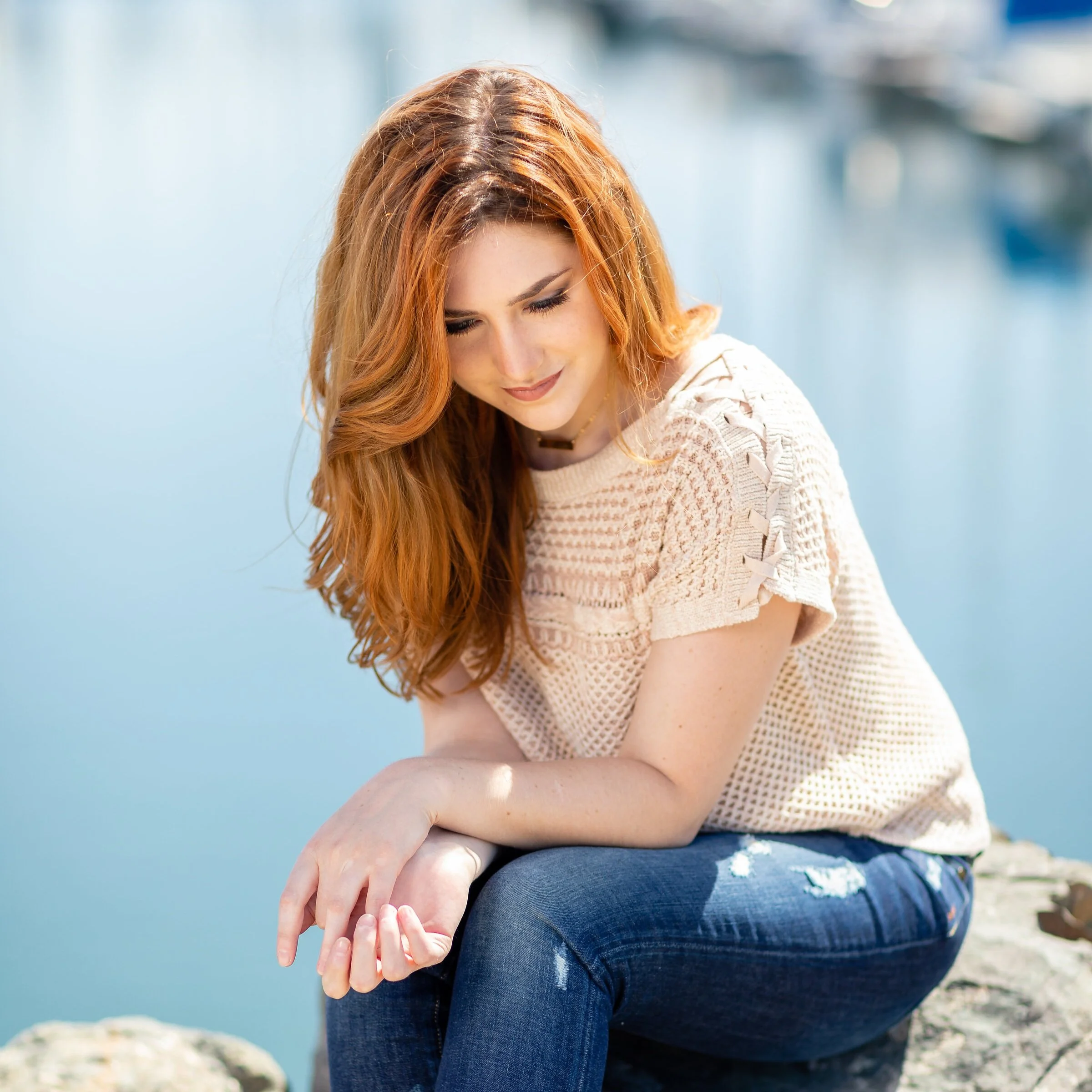 Woman+sitting+on+rocks+along+the+harbor.jpg