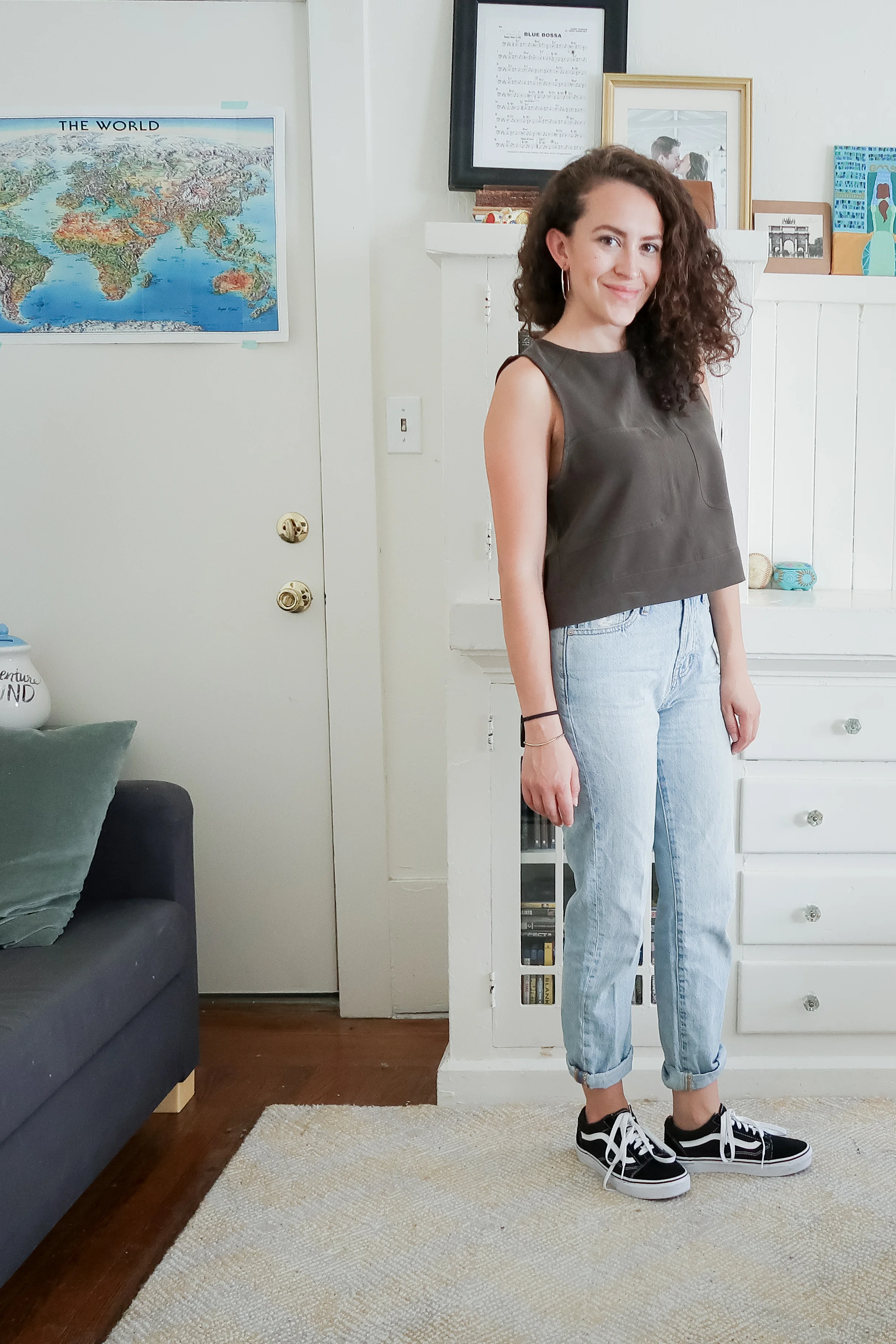 10 pieces, 10 outfits -- an olive green boxy crop top worn with light wash high rise mom jeans (aka the perfect summer jean from madewell) and low top old skool vans sneakers