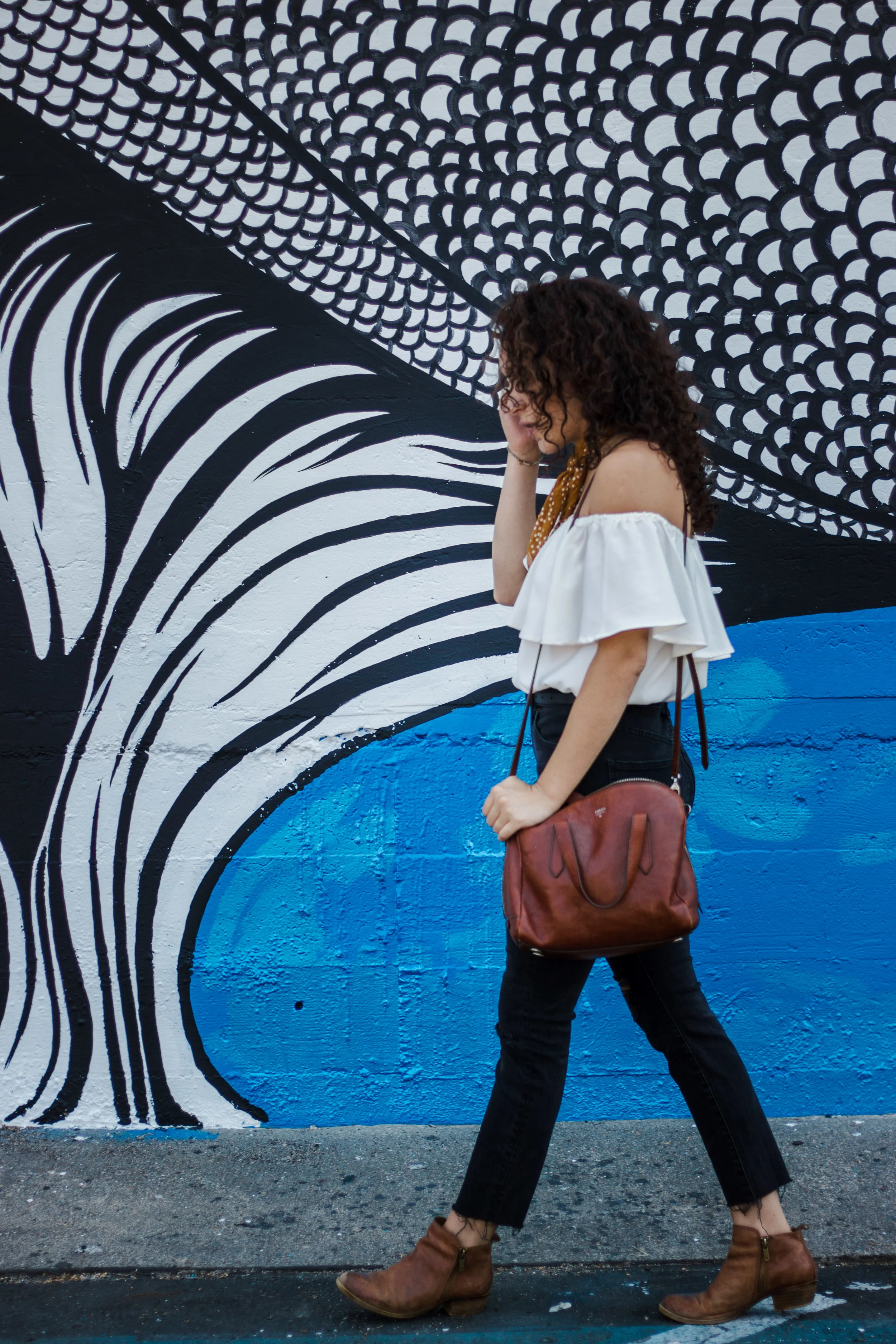 casual date night outfit -- black high rise skinny jeans (from madewell) worn with a white ruffled off the shoulder top, ankle boots and a bandana around the neck and a fossil satchel bag