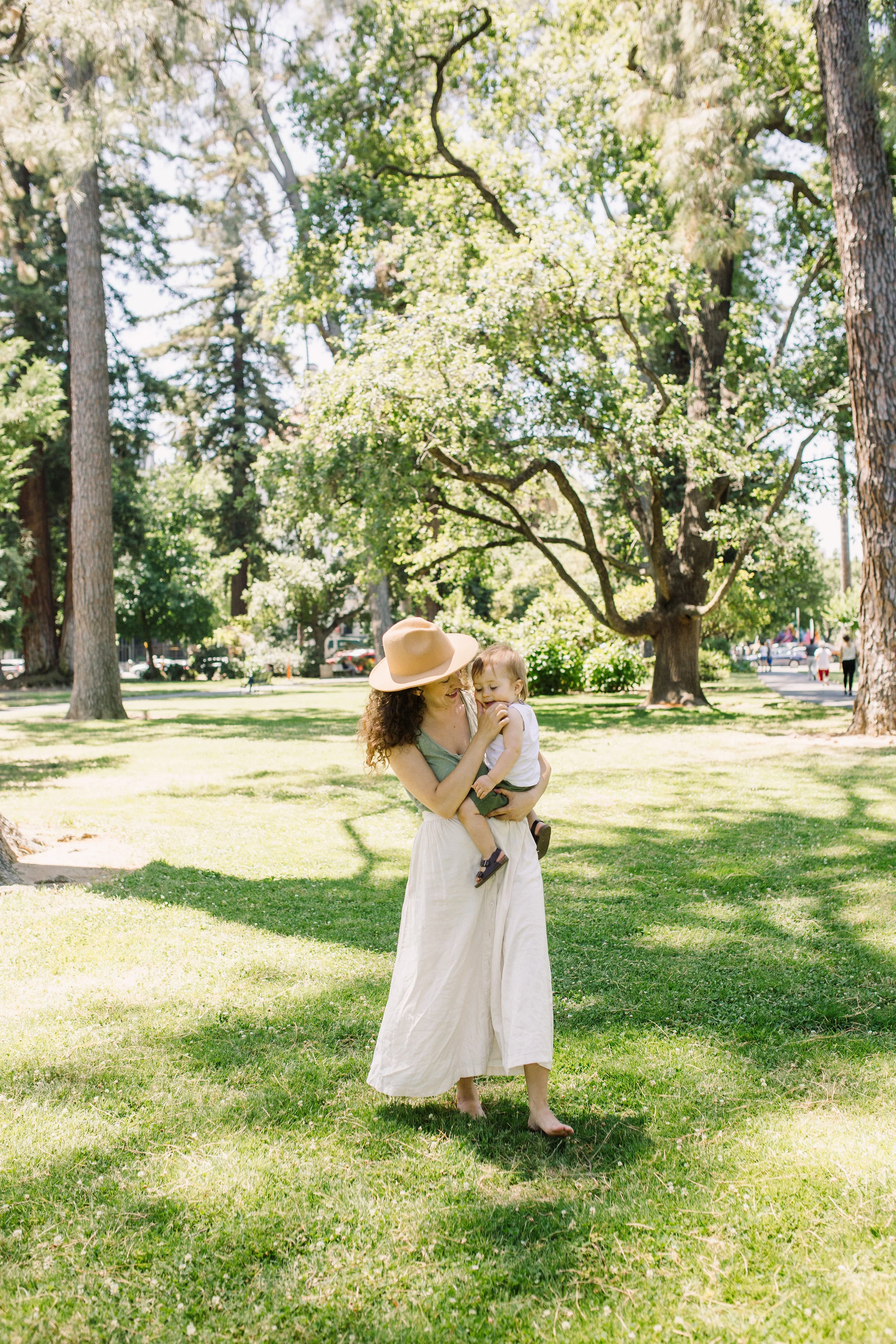 wearing a hat with curly hair - summer picnic in the park outfit: wearing sage green tank top from madewell and button up midi skirt from urban outfitters purchased secondhand on poshmark - sacramento, california - tinted-green.com - photos by sarah akiyama