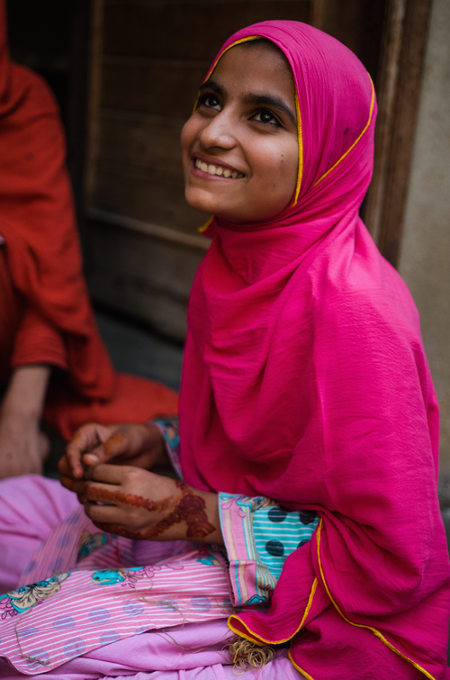 Aqsa sitting at her home in Machar Colony with her family.