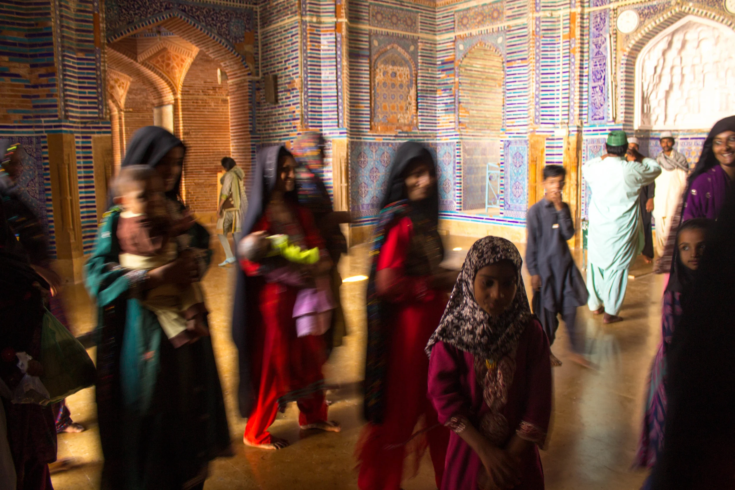Sindhi women show the children in their family the interior of the masjid before settling in the shade of the courtyard outside (photo by Olivia Curl)