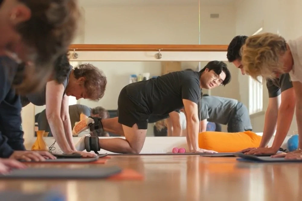 Physiotherapisty Minh leading a matwork Pilates class
