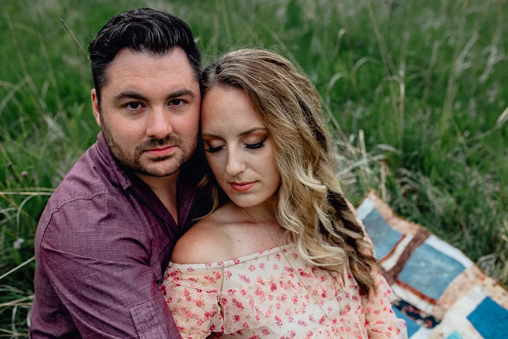 engaged-bride-and-groom-laying-in-field.jpg
