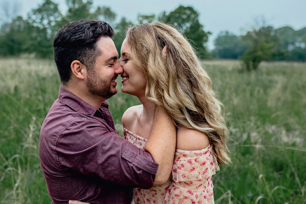 engaged-bride-and-groom-lkiss-in-field.jpg