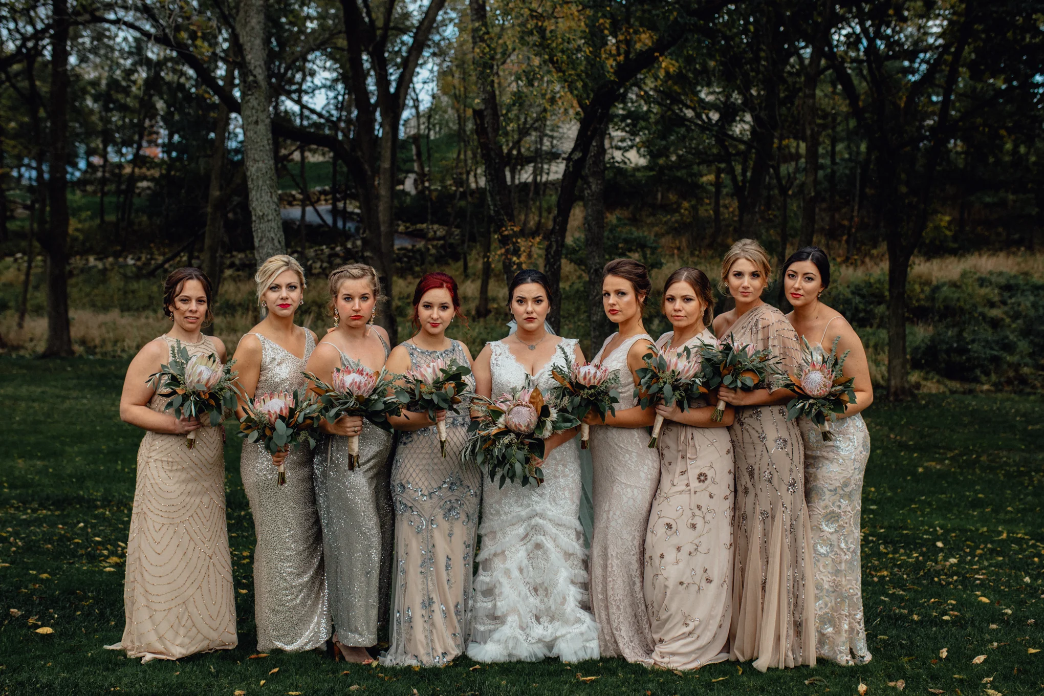 bridesmaids posing with bouquets in grass