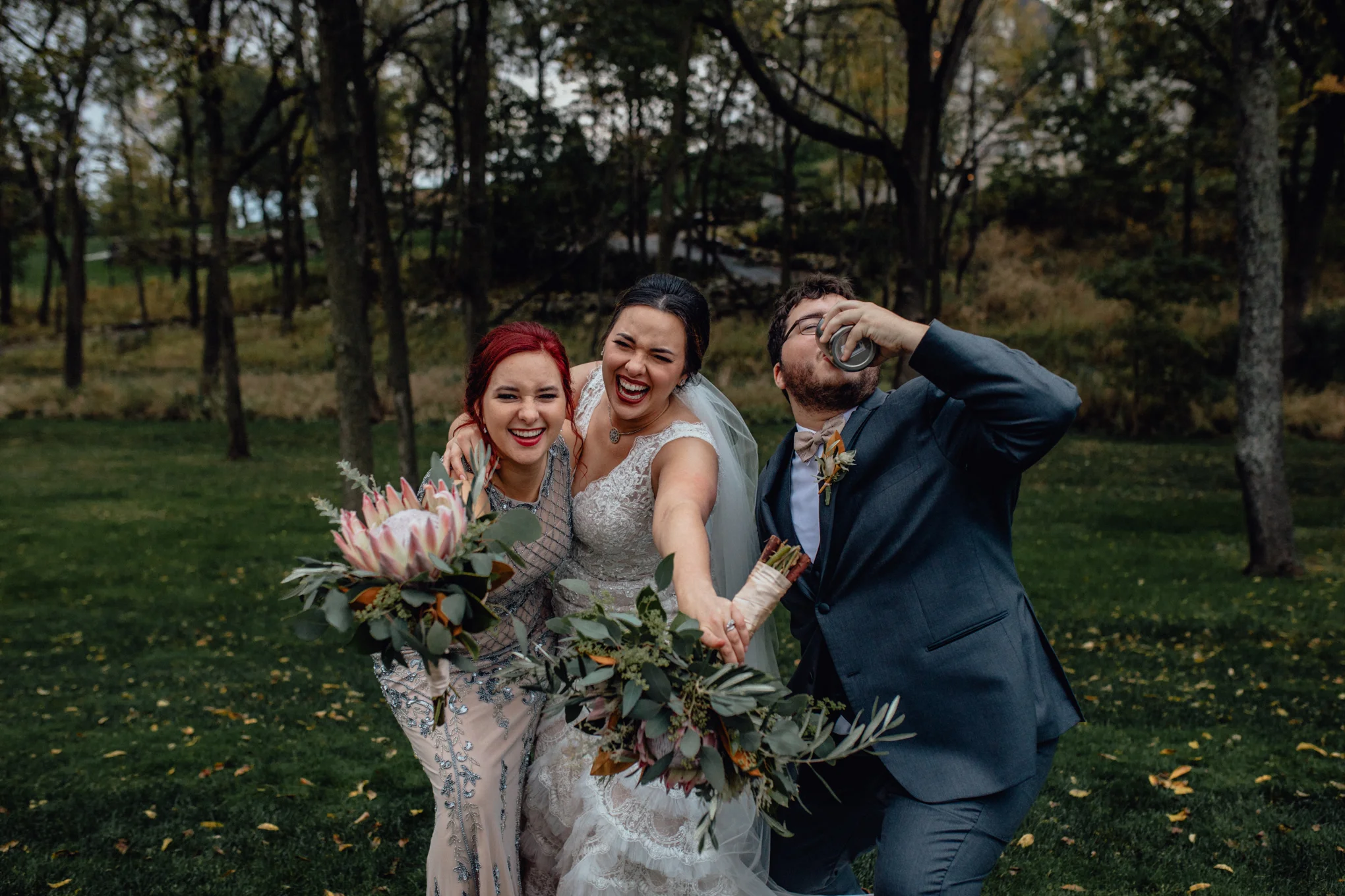 bridesmaid-and-groomsman-smiling-with-bride-in-grass.jpg