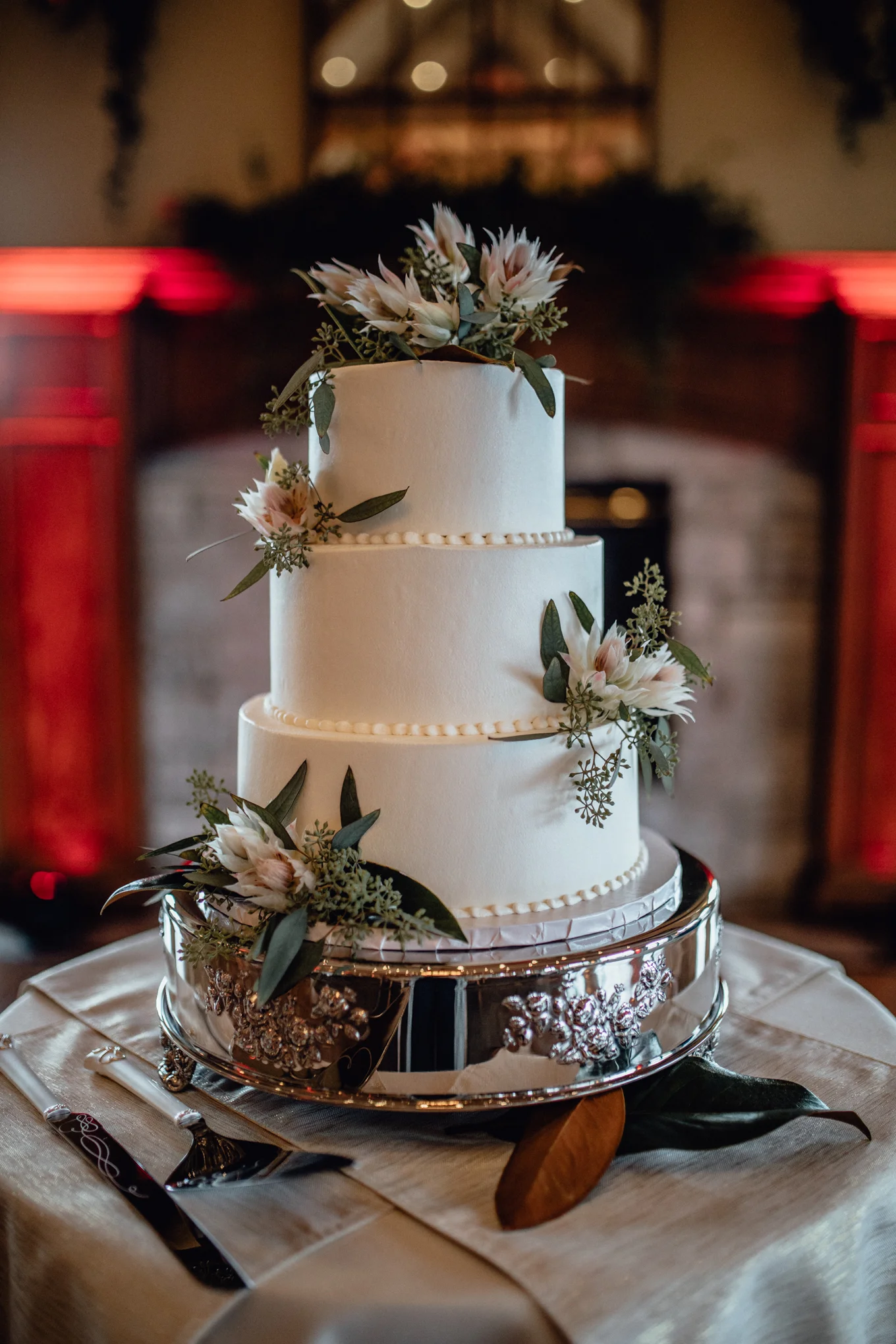 white cake on table with flowers