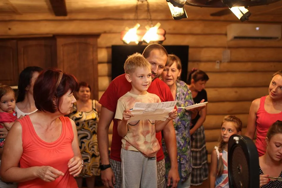 Ravil with a kid reading the programme of the camp.