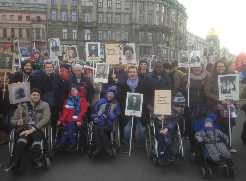 Lewis Purcell with children from Camp "Babochka" getting ready to join Immortal Regiment on Nevski. The photos they're holding are their relatives who participated in WWI