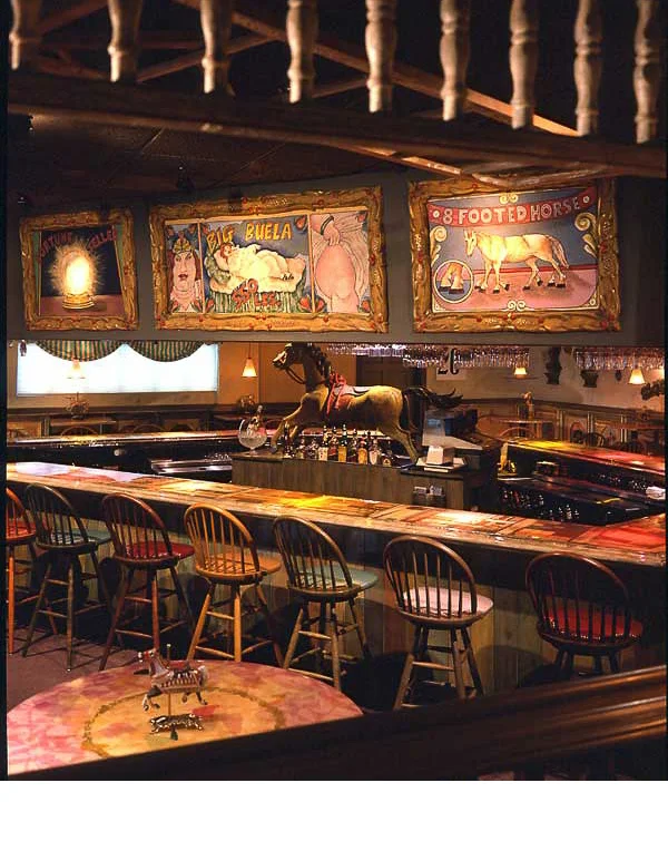 Carlos Alfonzo, who shortly after this restaurant was built became well acknowledged as an internationally acclaimed artist, designed and painted the circus art on top of the bar.