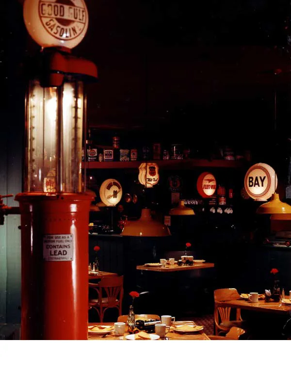 Old gasoline pumps, oil cans, and garage memorabilia, pulled from the owner's storage, were the inspiration for this luncheonette.. 