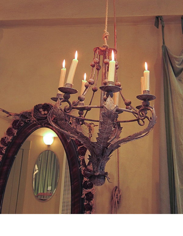 Large candle chandeliers and long wool and silk trimmed curtains, offer an elegance to the shop.