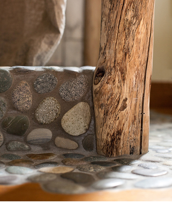 A scribed design cut out of the original floor was installed with river rock.