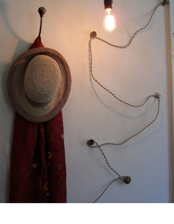 Vintage buttons attached to the wall, catch the cords leading to the ceiling.