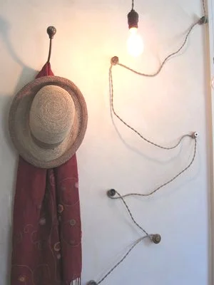 Cloth wire winding up a wall supported by vintage buttons and rubber washers.