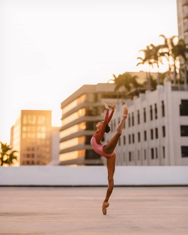 🌅

#ballet #brownballerina #dancephotography 

🩰: @margauxgisele 
📸: @rhileephotog 

Image Description: Dancer poses in a high attitude position en pointe. She is on a rooftop with many buildings in the background. She is wearing a pink leotard.