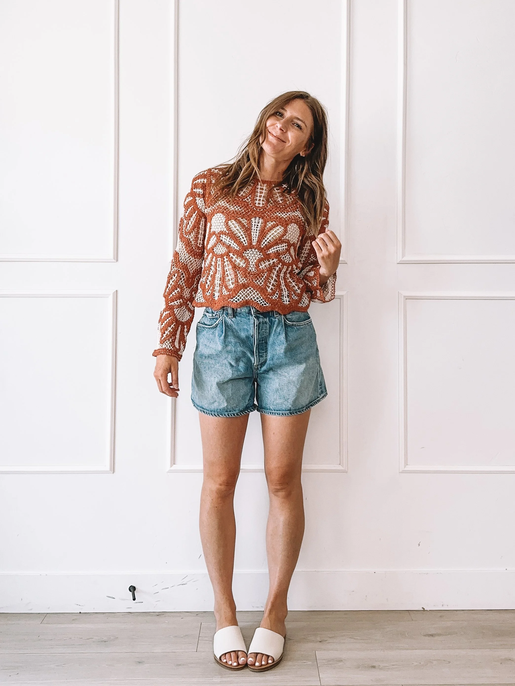 Woman wearing a rust crochet sweater styled for an easy everyday summer look.