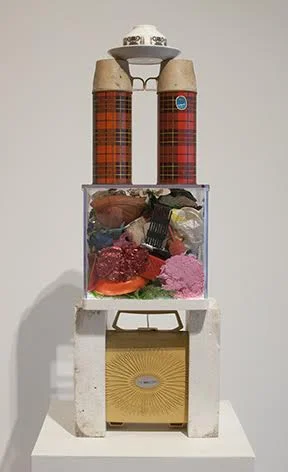 Illuminated Totem—Tea Time (2017). Styrofoam, electric hair curler in case, acrylic display box, assorted plastic trivets, thermos vacuum bottles, ceramic cup and saucer. 32 x 11 x 9 1/2 inches