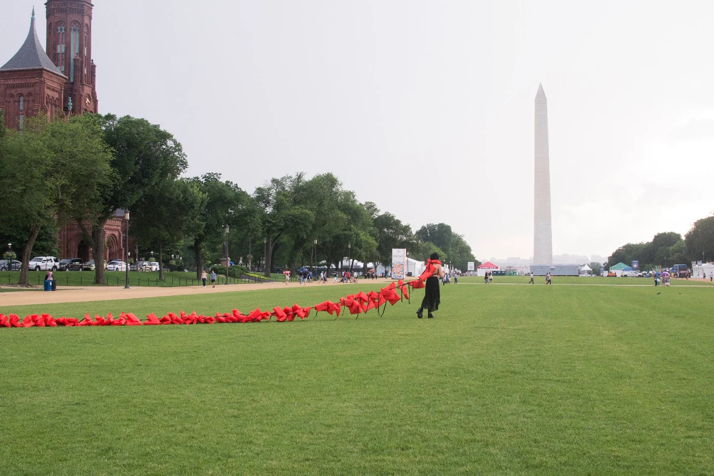 Repatriation -performance on the National Mall that began inside the Smithsonian Arts & Industry Building for By the People 2018 hosted by Halcyon Arts Lab, 2018, 86 life vests, Buddhist chime, & audience participation, varied dimensions