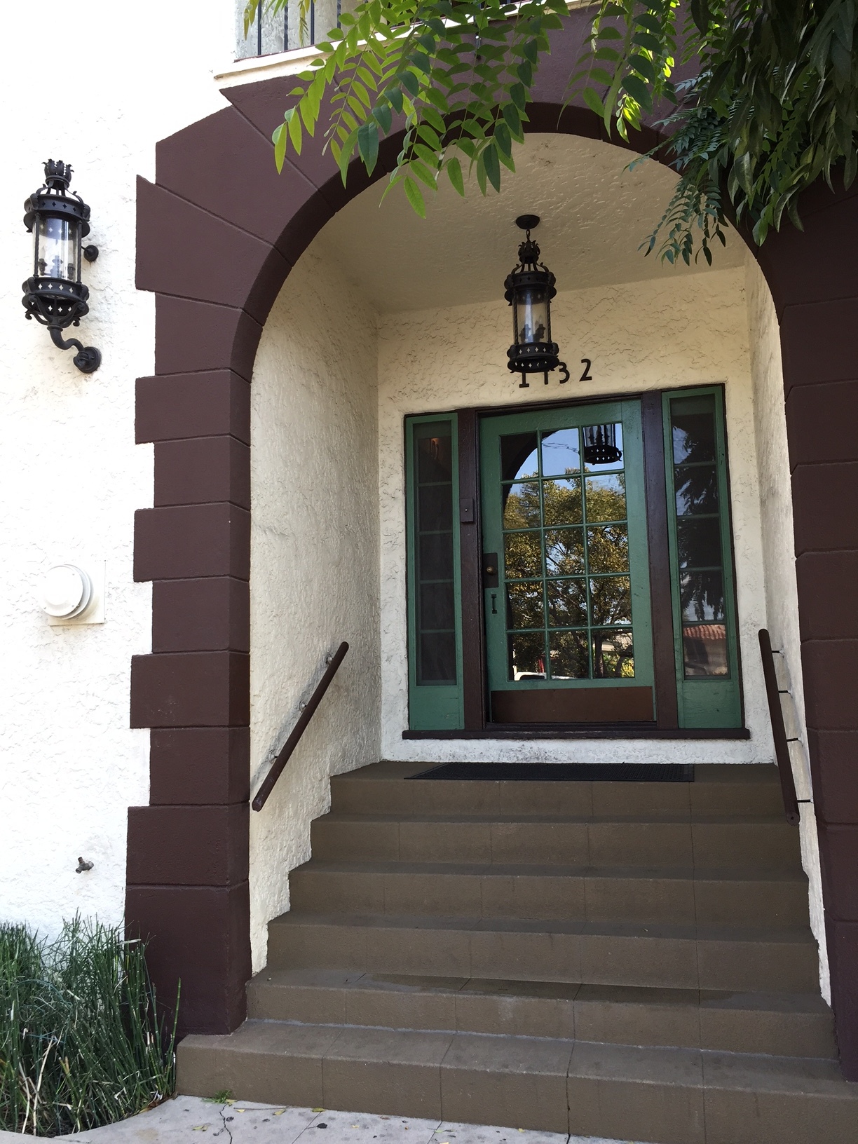Over-sized lanterns and a full restoration of the original stucco and paint job renews this beauty. 