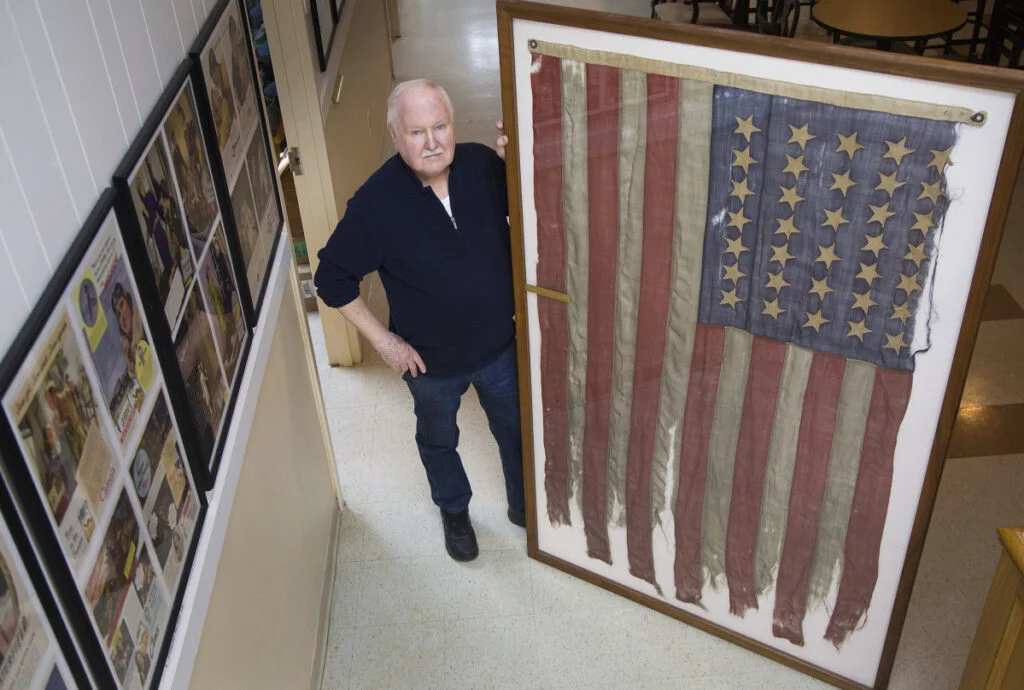 Lee Humiston of the Maine Military Museum receives flag from the Civil War that he says was the first to fly over Texas shores. The flag belonged to Major James H. Whitmore of the Fifteenth Maine Regiment. Staff photo by Derek Davis