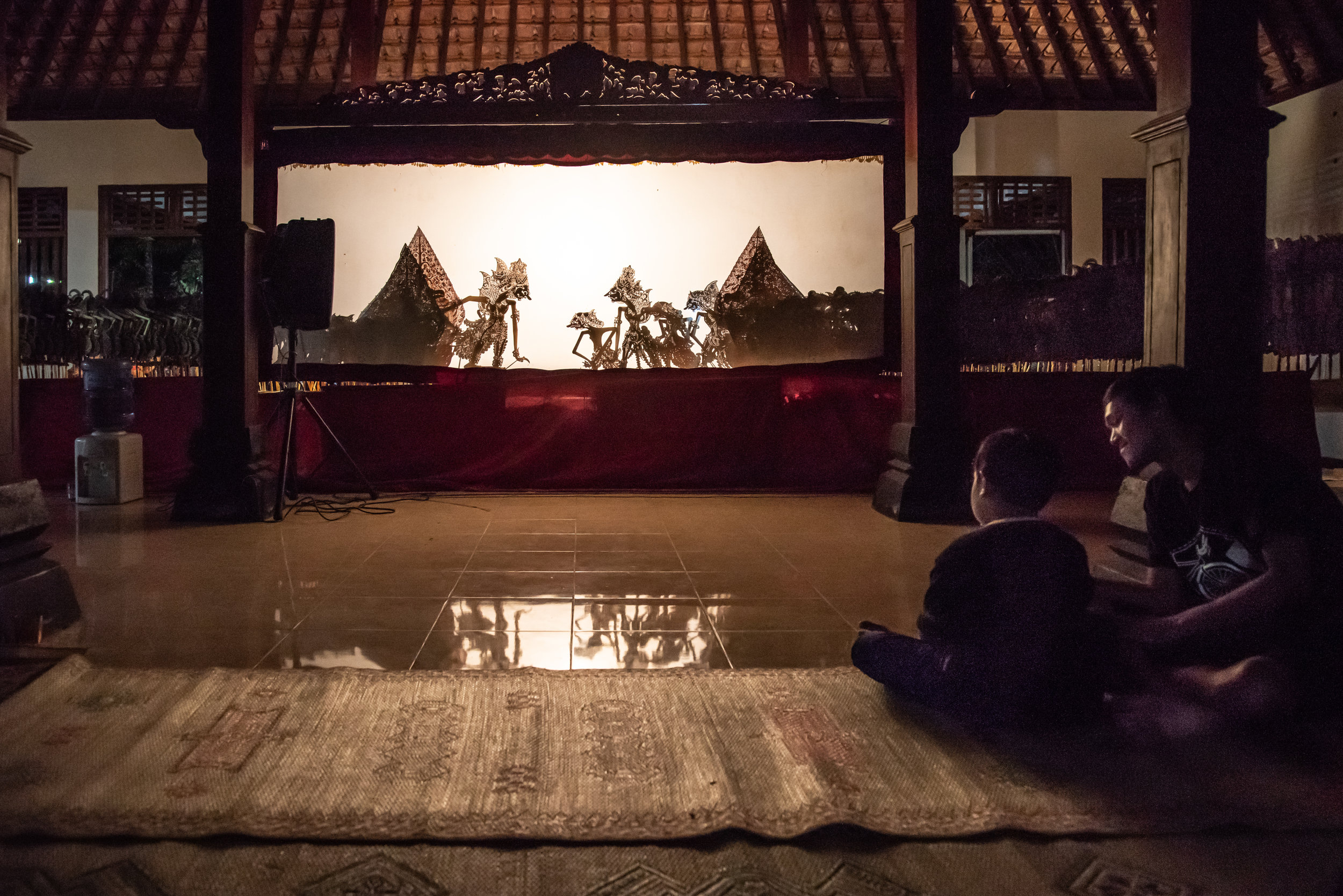 Father and child enjoy the local Wayang Kulit performance