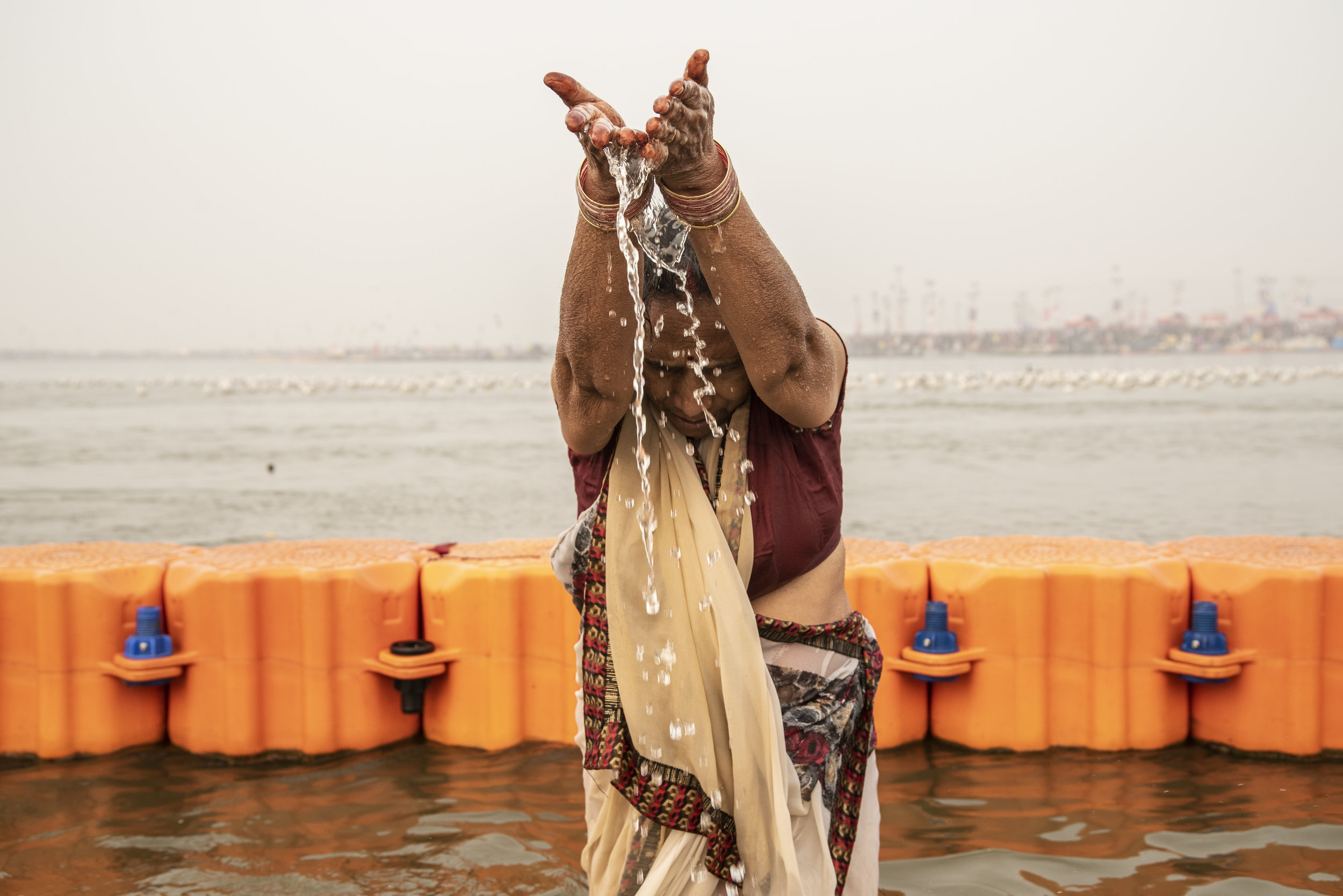  Woman pours the holy water of the Ganges from her hands 
