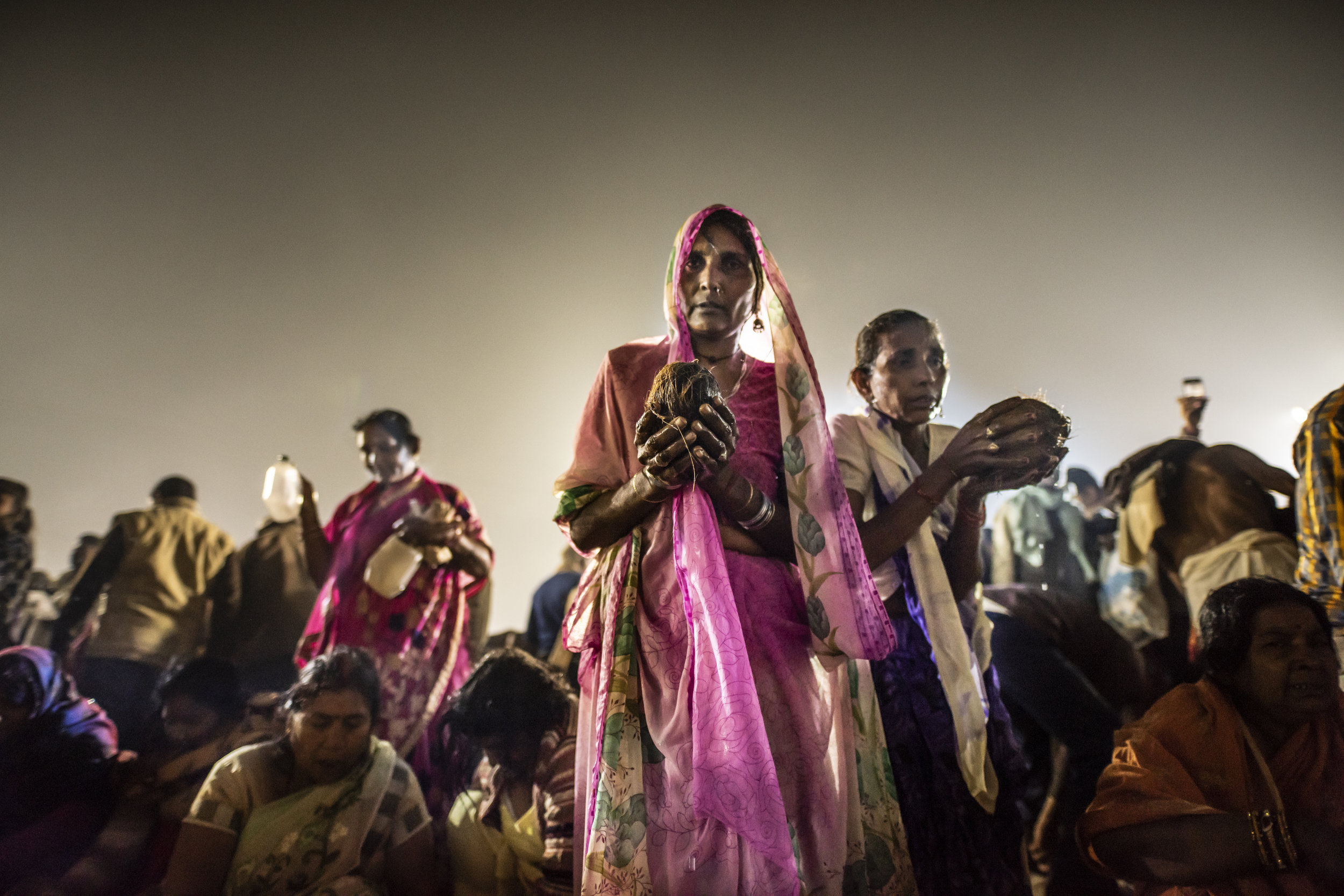  Women push through the crowd to bring puja offerings to the Ganges. 