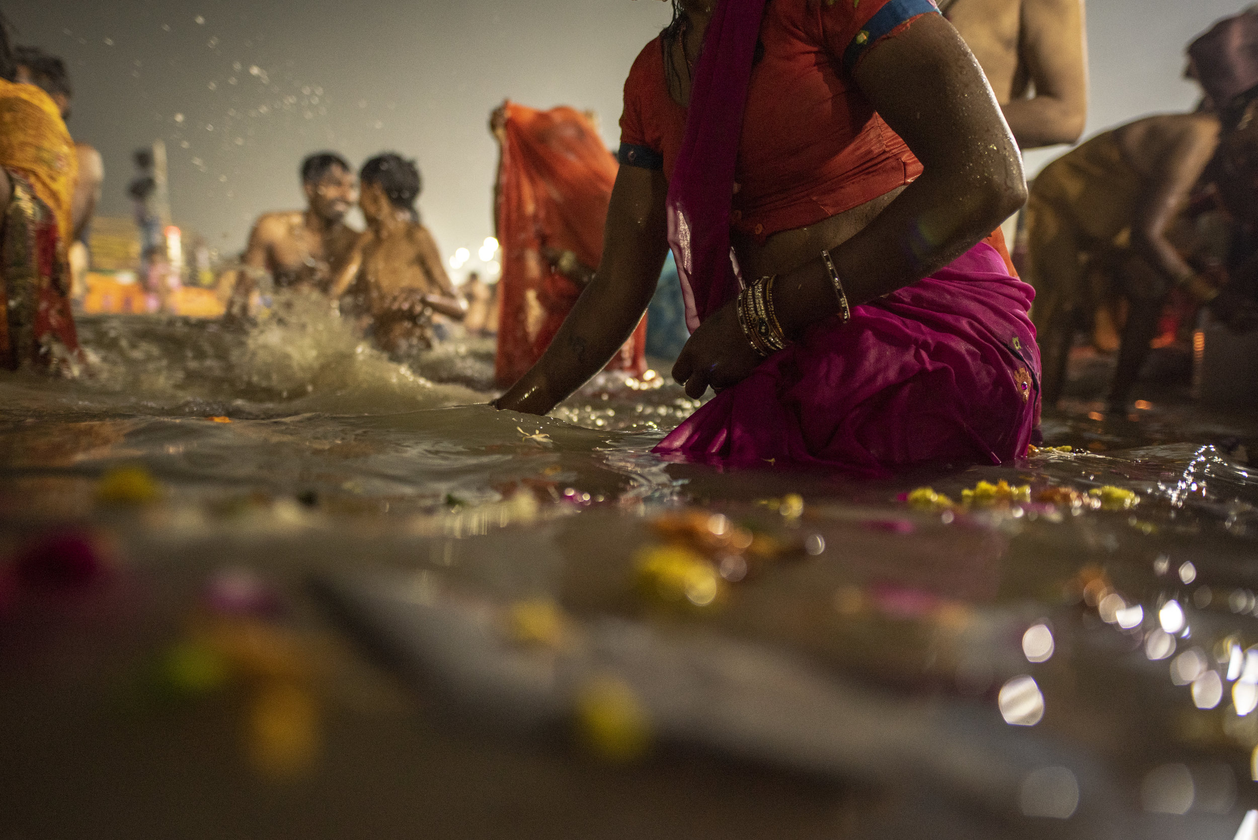  Petals float in the Ganges as men and women gather to bathe 