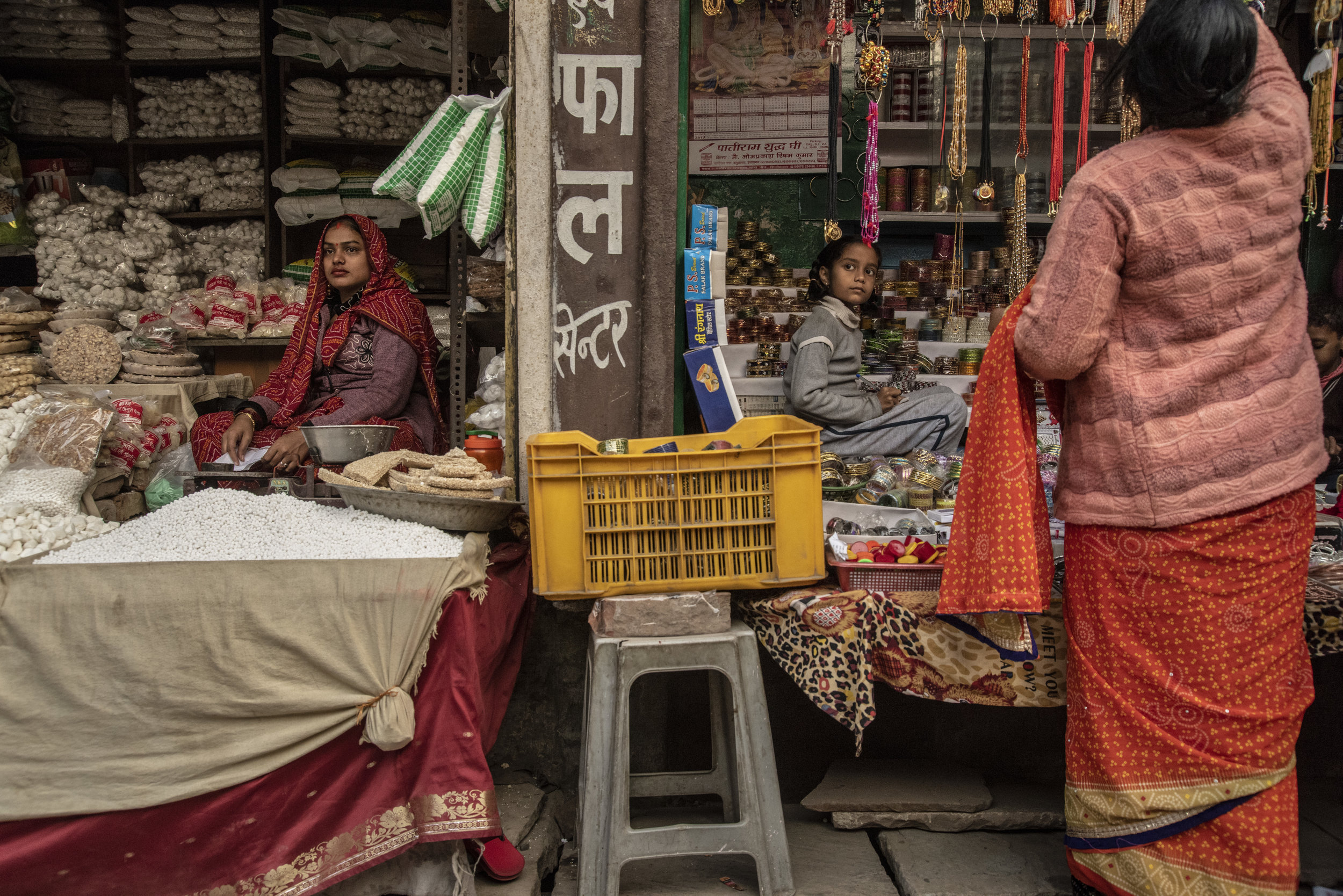  A woman and a young girl in a market in Allahabad, though divided, share the same expression 