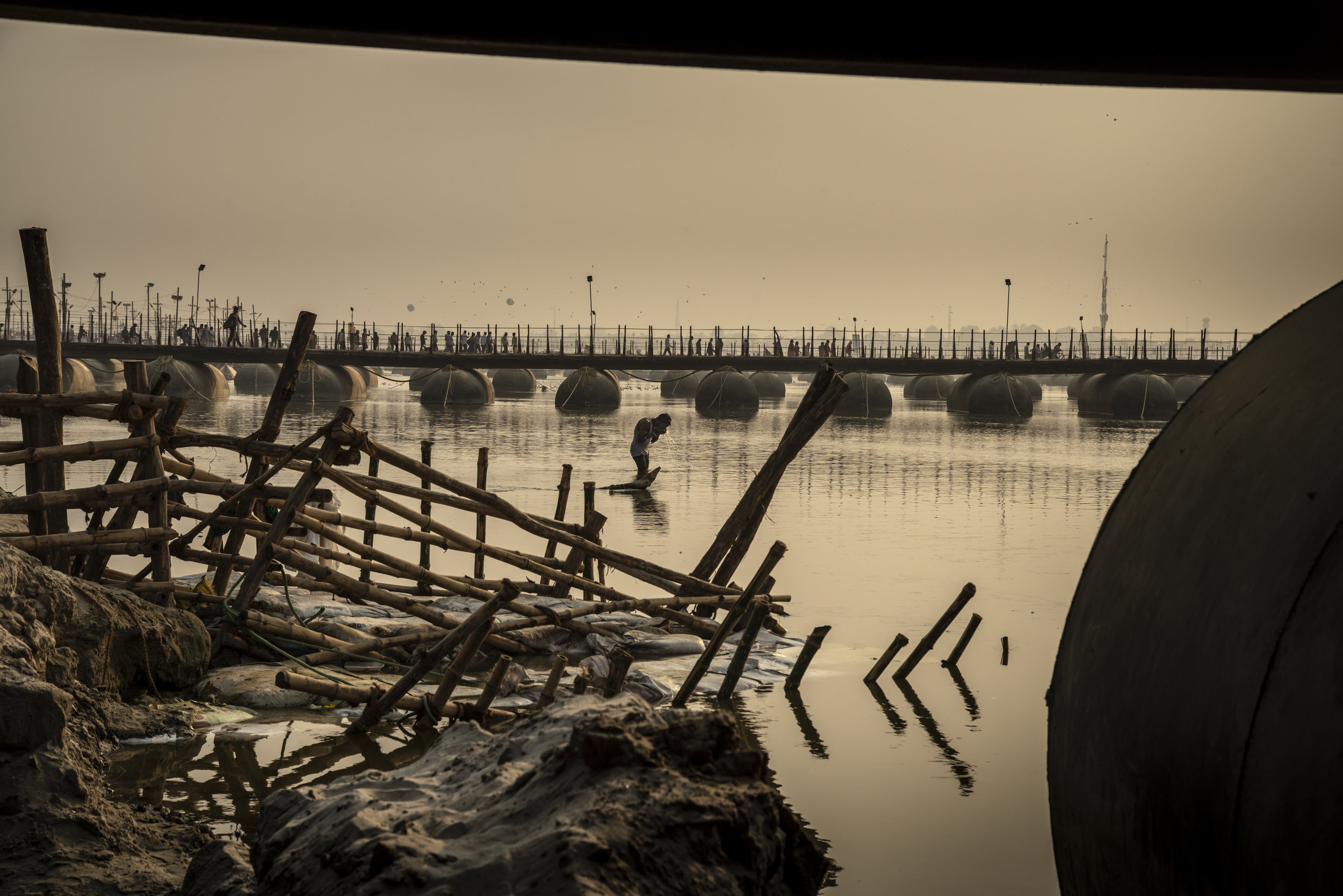  Man bathes in the Ganges betweenba series of temporary bridges 