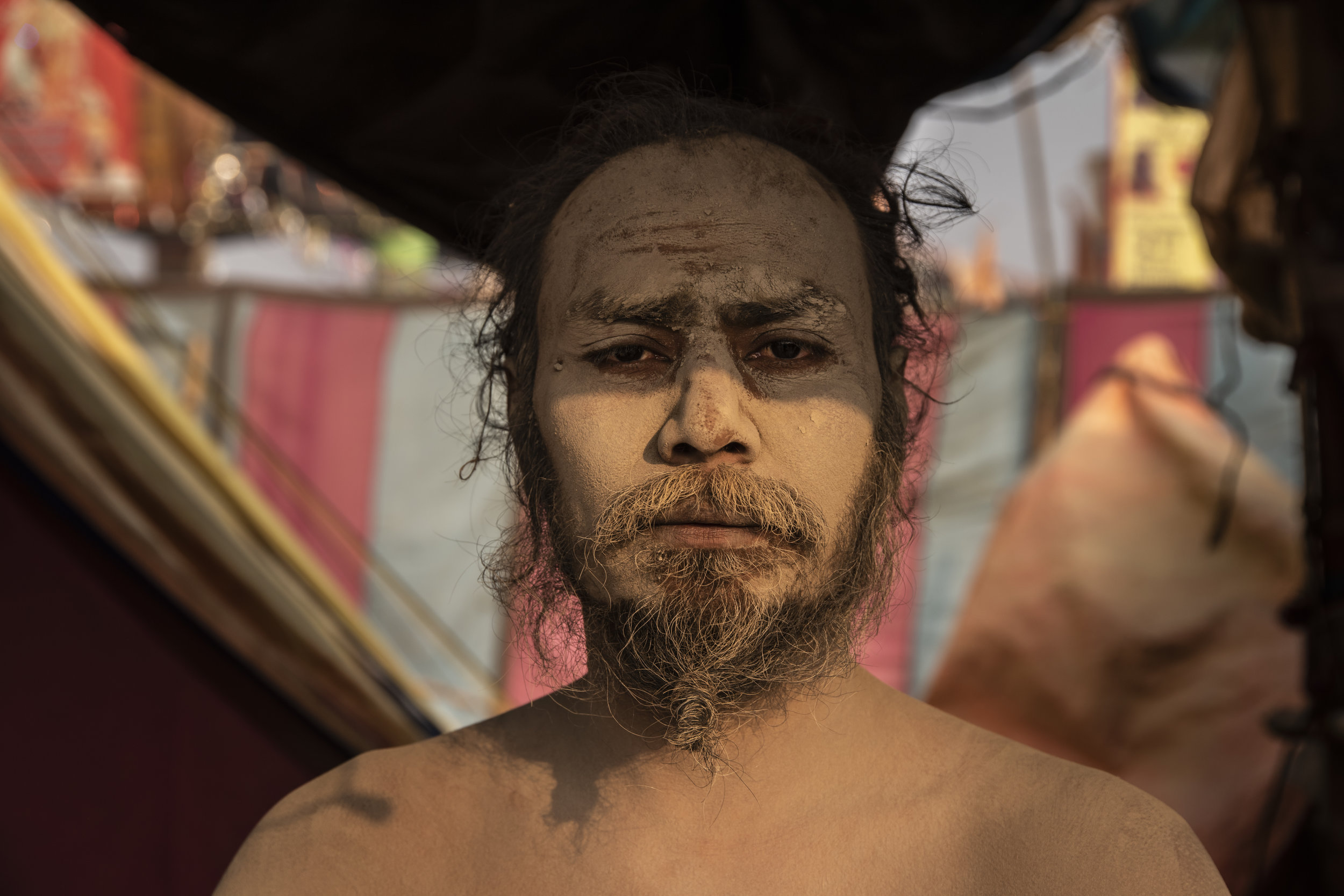 A Naga Sadhu meditates in his tent, offering blessings to those who pass.