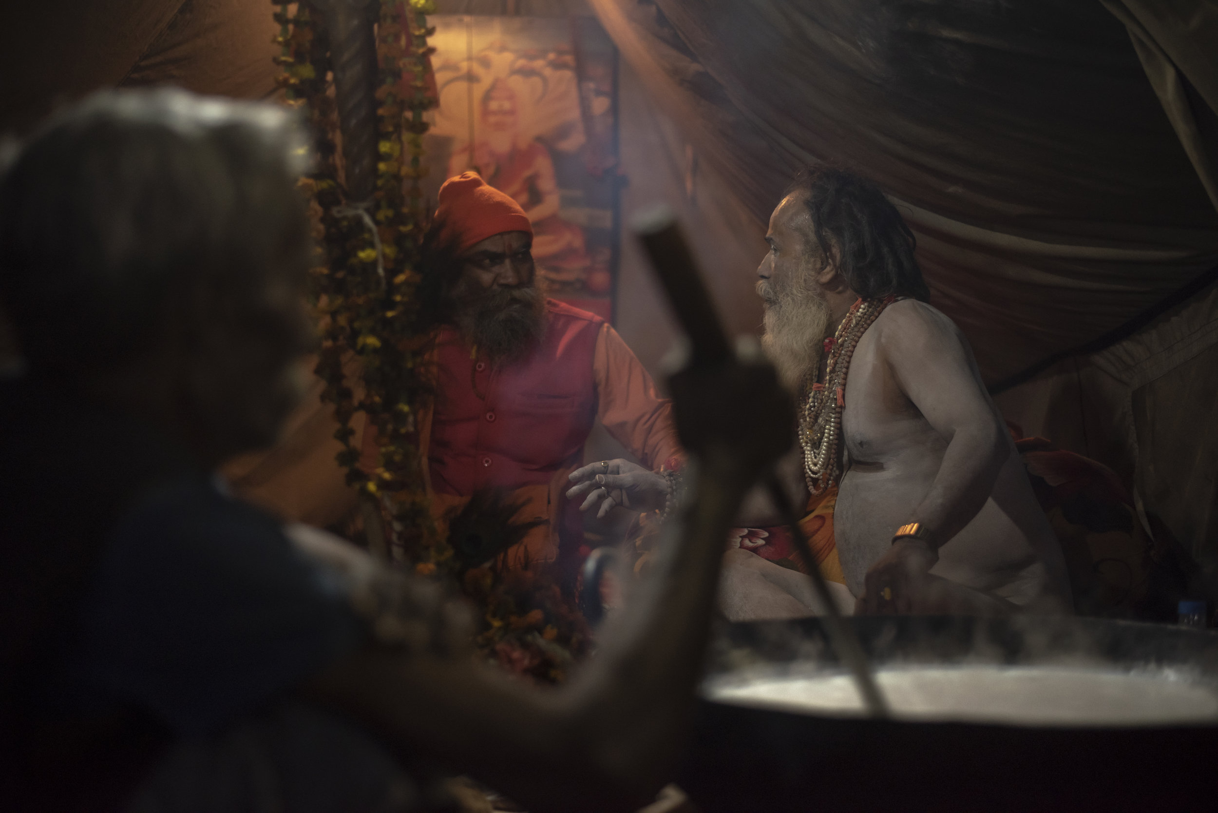 Two sadhu’s (Hindu sages/priests) converse while a man stirs a giant kettle of milk representing the Samudra Manthan, an auspicious ocean of milk from Vedic mythology.