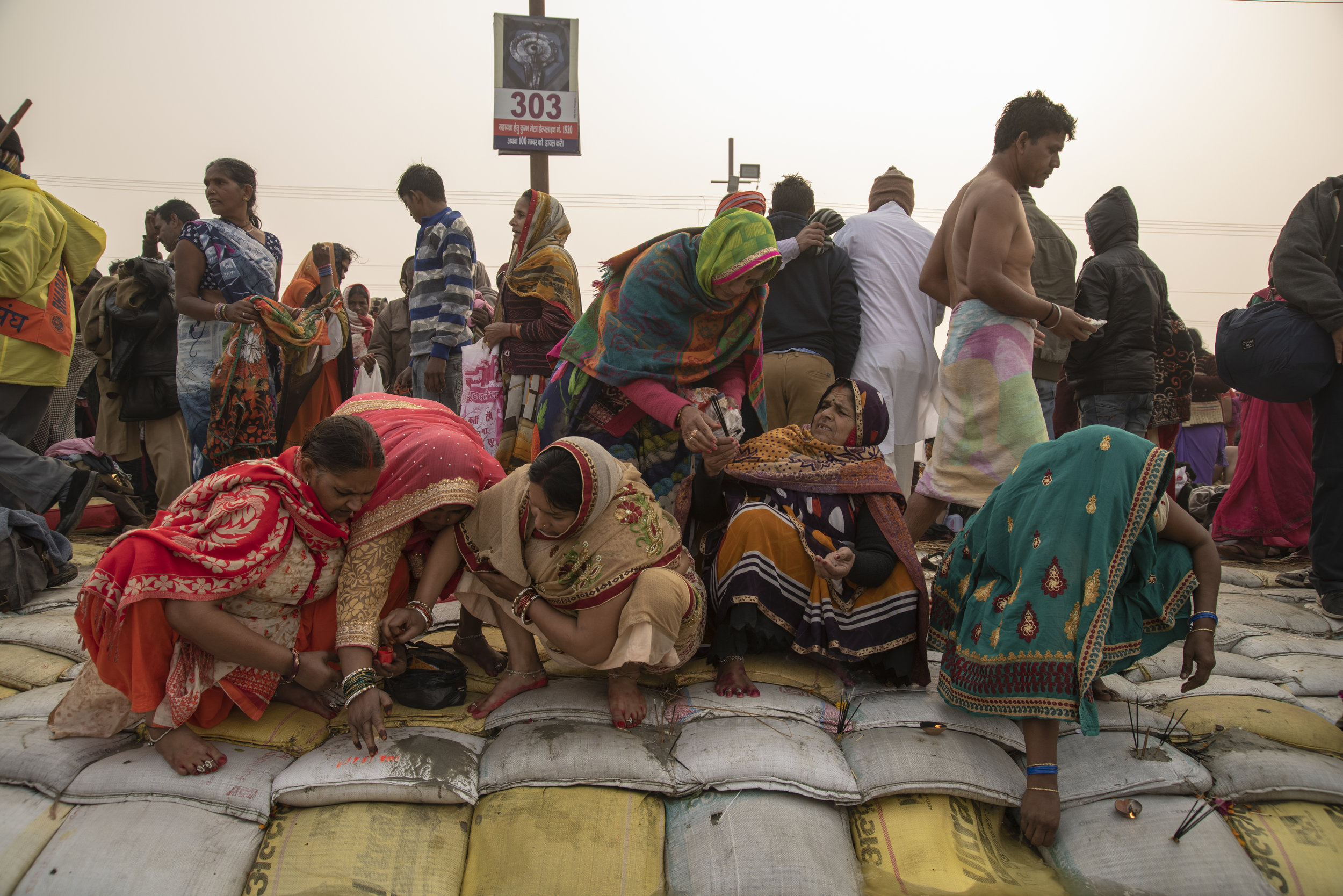 Women gather along the shore of the Ganges to give puja offerings