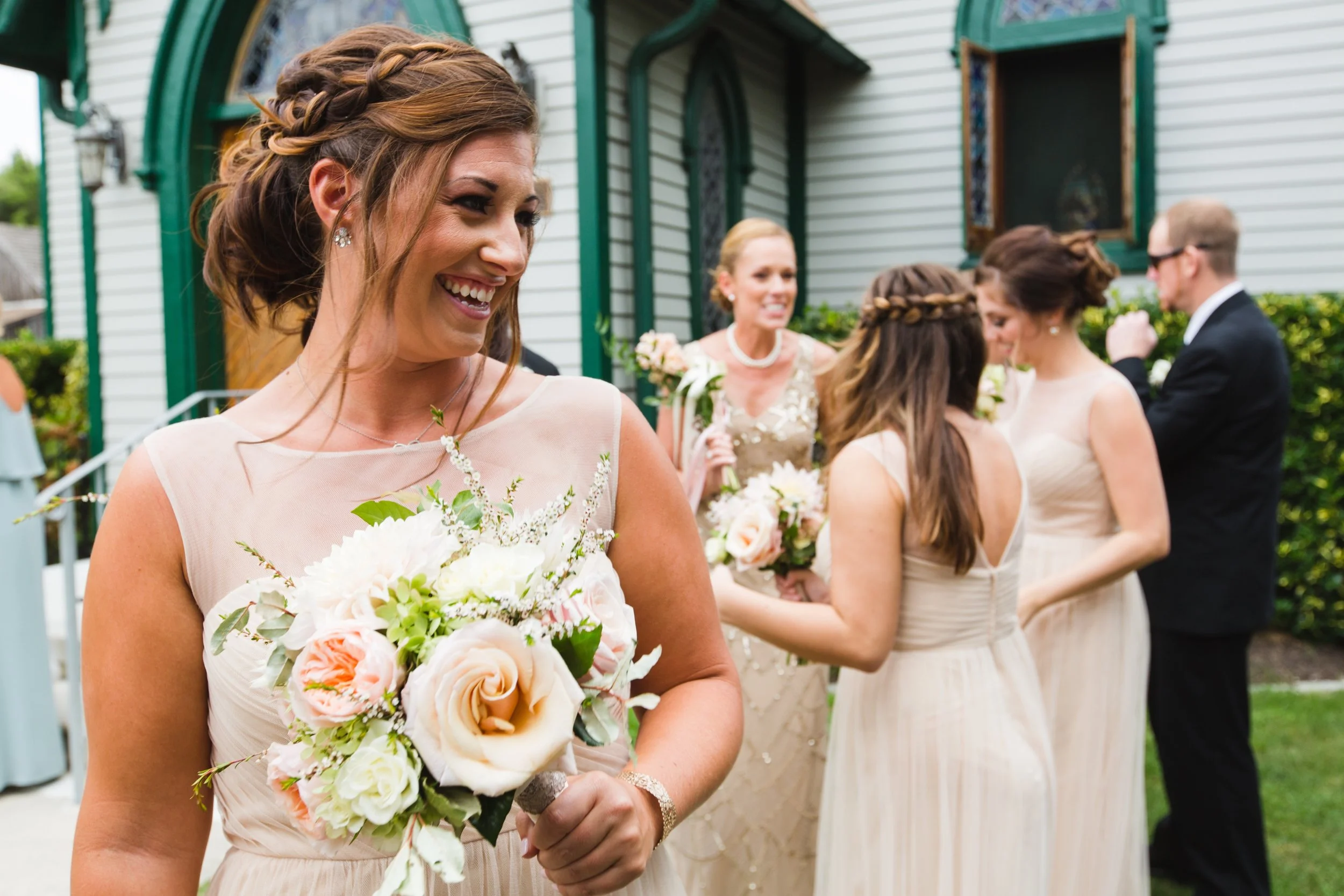 Bridesmaid in neutral gown with bouquet of blush roses