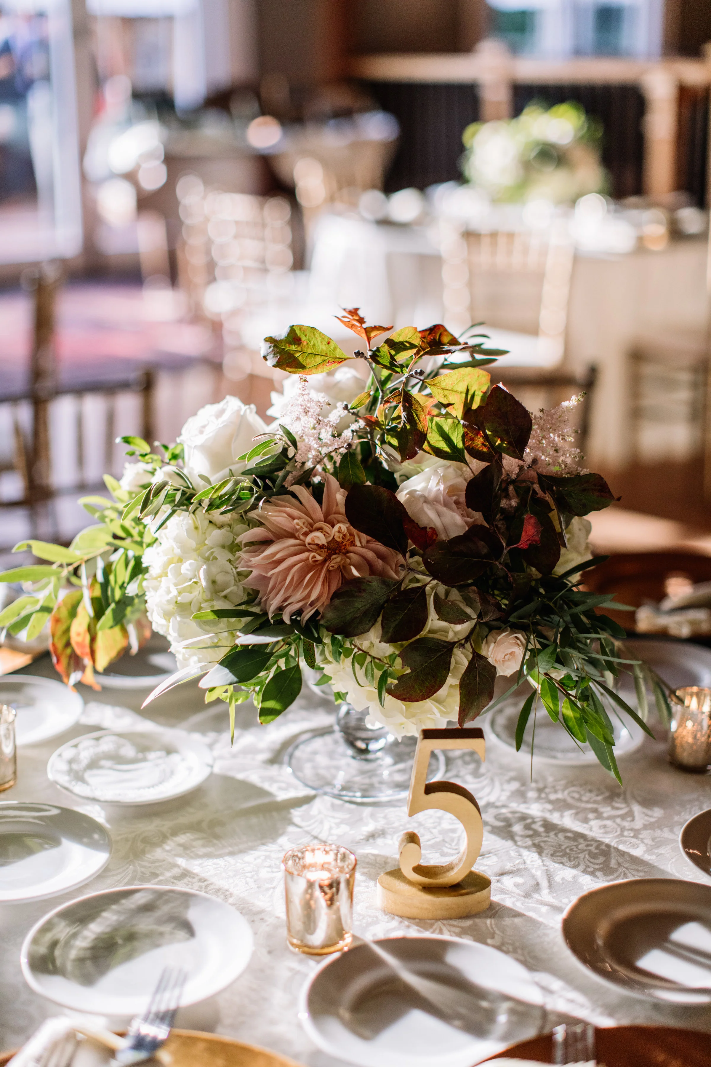 Centerpiece in glass urn with gold table number