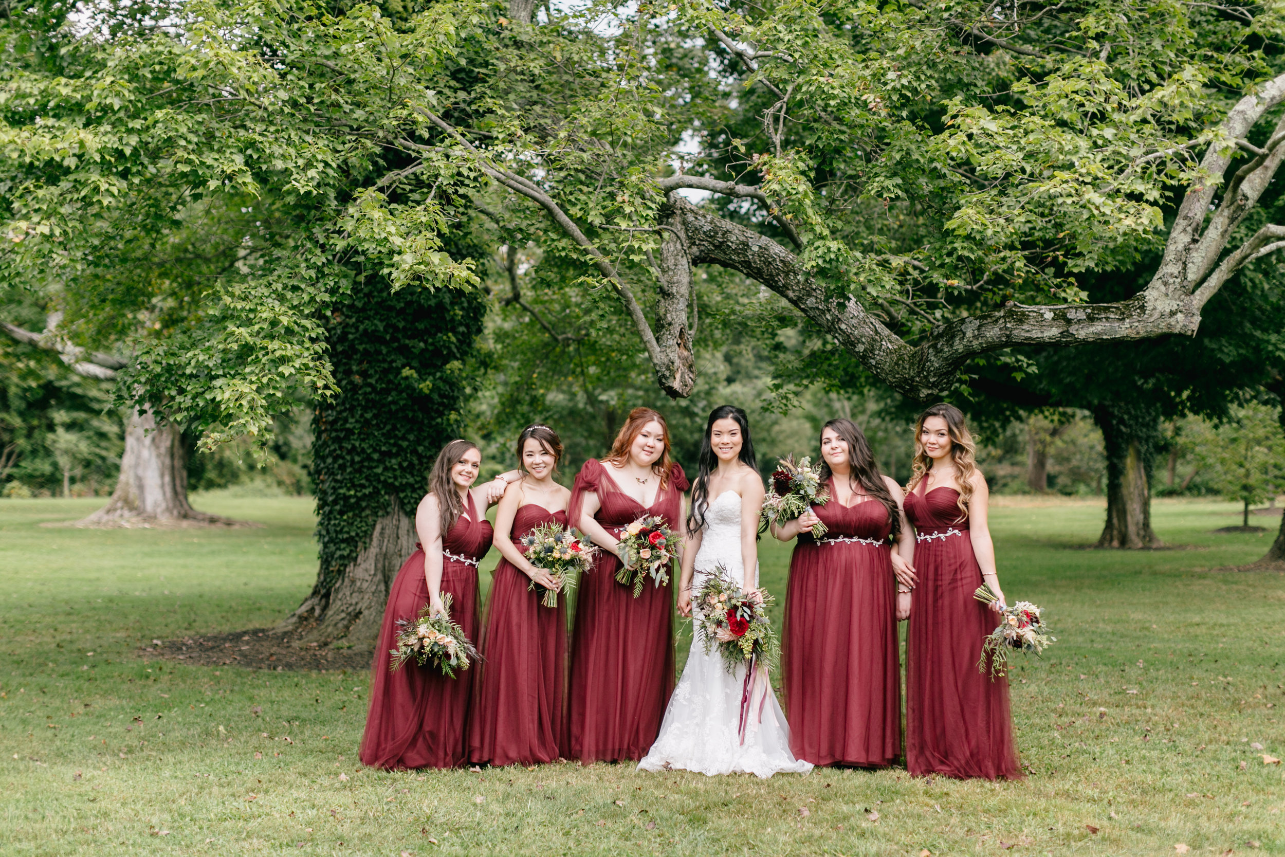 bride and bridesmaids posing in garden with bouquets