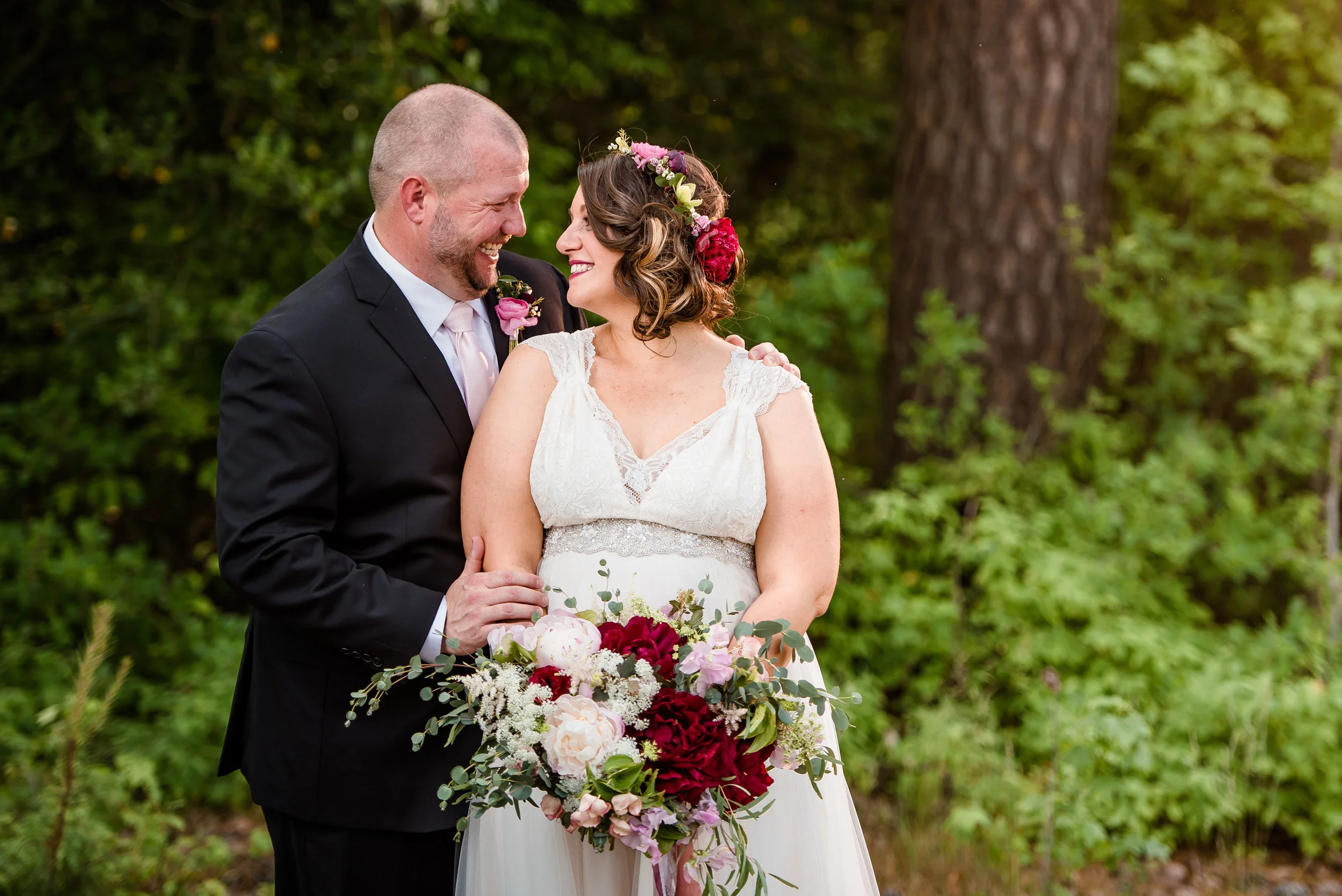 bride and groom posing with flowers