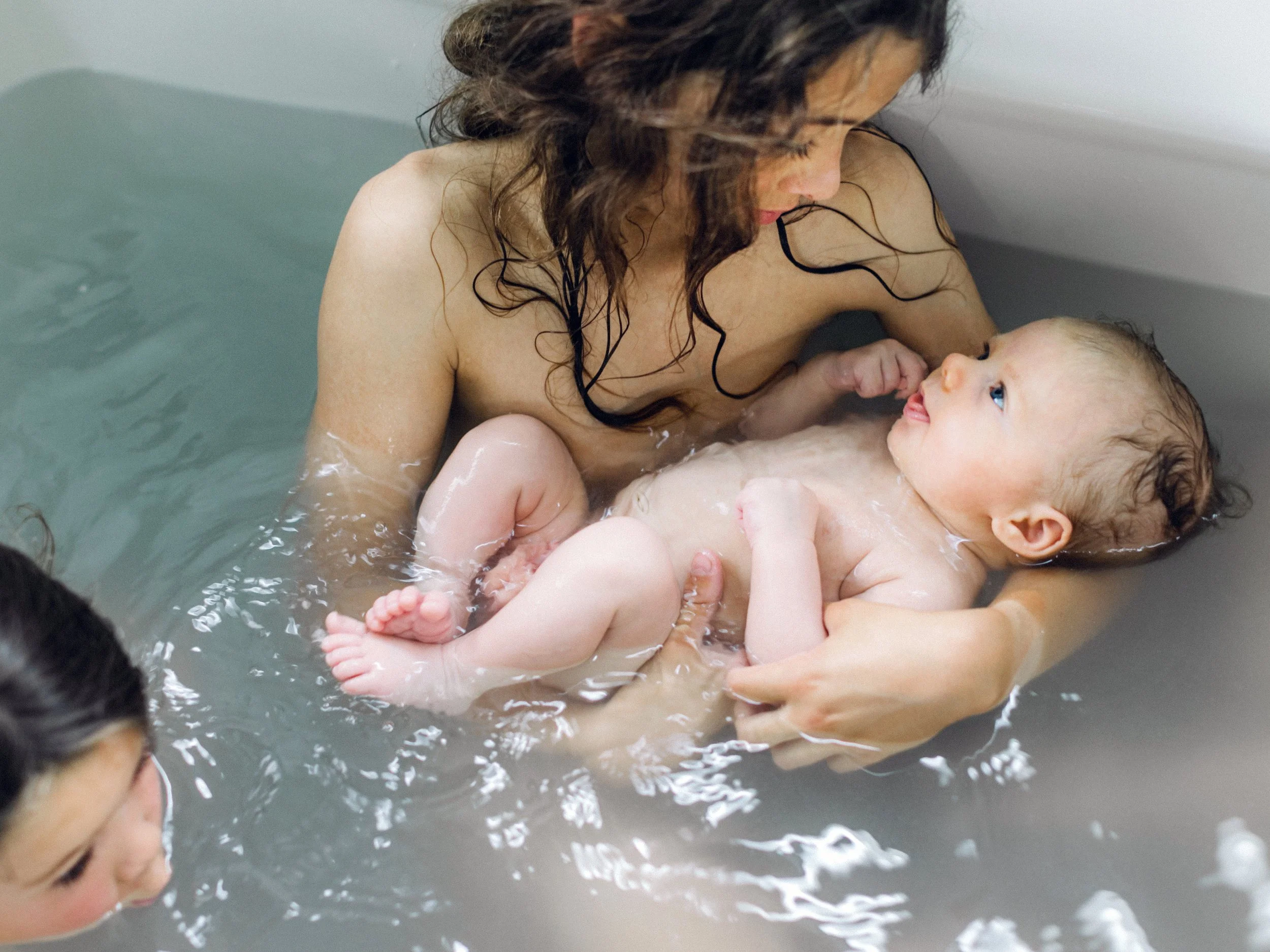 newborn taking bath with brothers