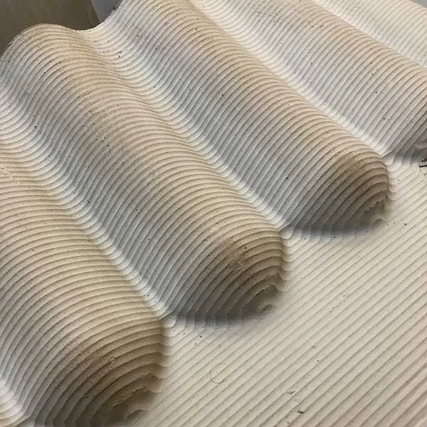Close-up view of textured foam or plastic material with ridges and grooves.
