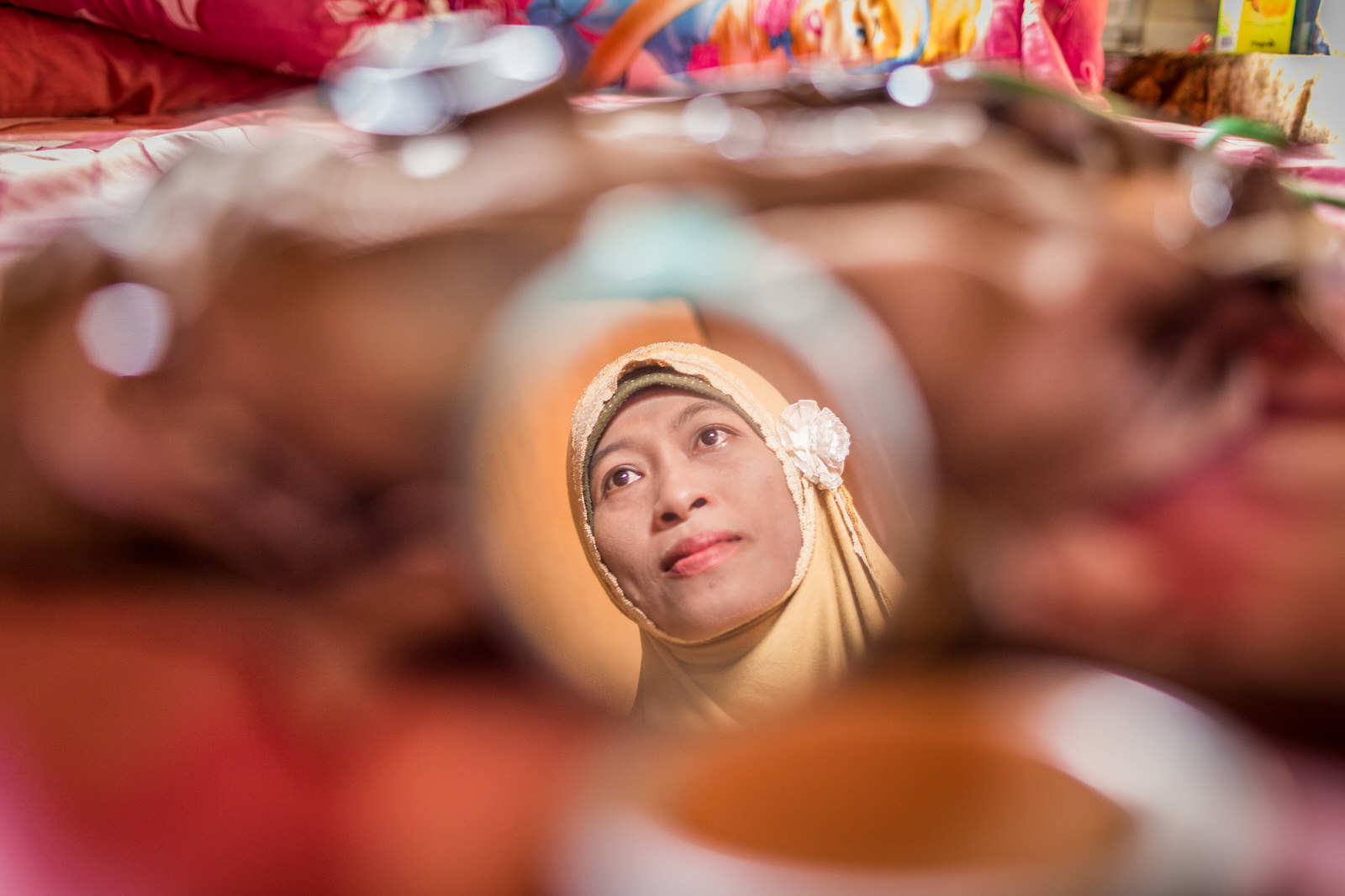  Ibu Ratna’s reflection on her mirror as she puts on makeup before going to school for work.