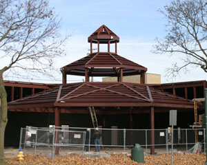 Newport West Gazebo: The incredible feature of this non-conventional gazebo is that the entire structure is clear span, self supporting and the inside is open all the way to the peak. Much time was invested in the planning and coordination of this non-conventional gazebo. The incredible feature of the gazebo is that the entire structure is clear span, self supporting and the inside is open all the way to the peak. This was achieved by leaning shop fabricated moment frames at the corners into a compression ring. The Asymmetric pattern of the structure complicated the process. A temporary tower at the center of the structure was installed and was removed after the entire field welded moment connections were complete. To complicate things further, being built on a city lot, the delivery of the components had to be carefully coordinated so not to choke the other activity on the site. The temporary tower was supported on anchor bolts with double nuts so the tower could be gradually lowered and any deflection of the structure could be monitored. There was only one eighth of an inch drop after the tower was removed. The time invested in the planning paid dividends as the structure was completed weeks ahead of schedule.