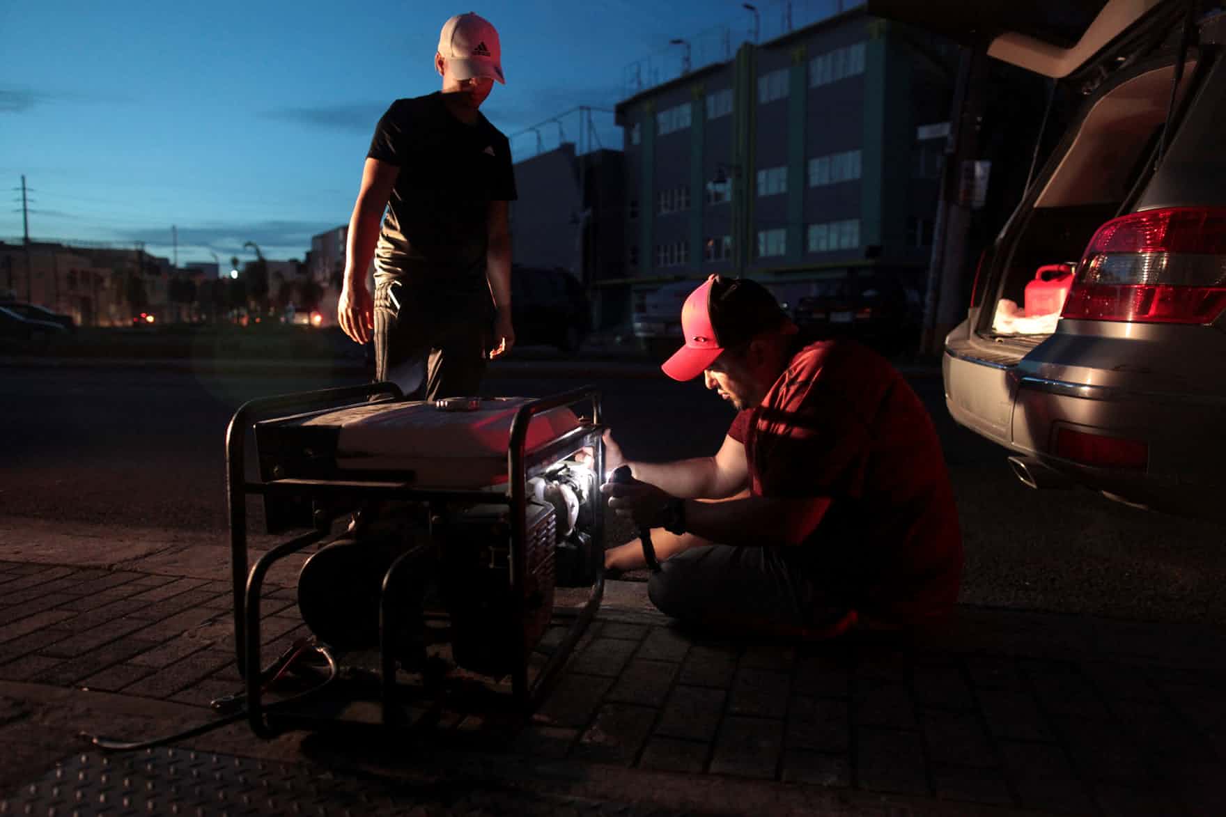 Man tries to repair generator in San Juan.