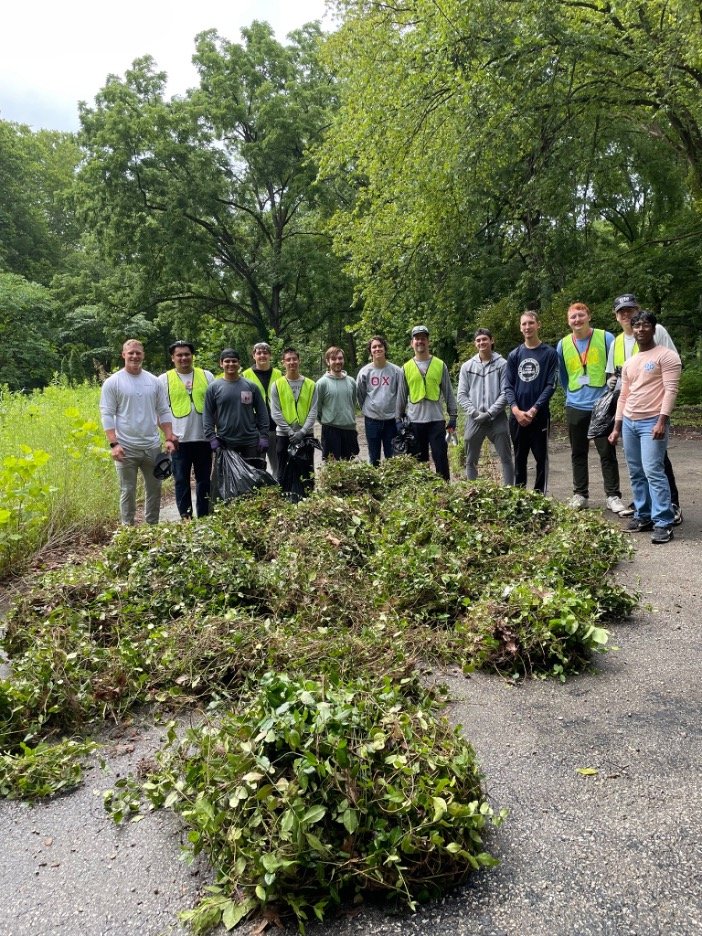  Piles of Euonymus fortunei   (purple wintercreeper) in front of men from Theta Chi Fraternity Weed Wrangle at Lower Cascades 2023. Photo by Gillian Field 