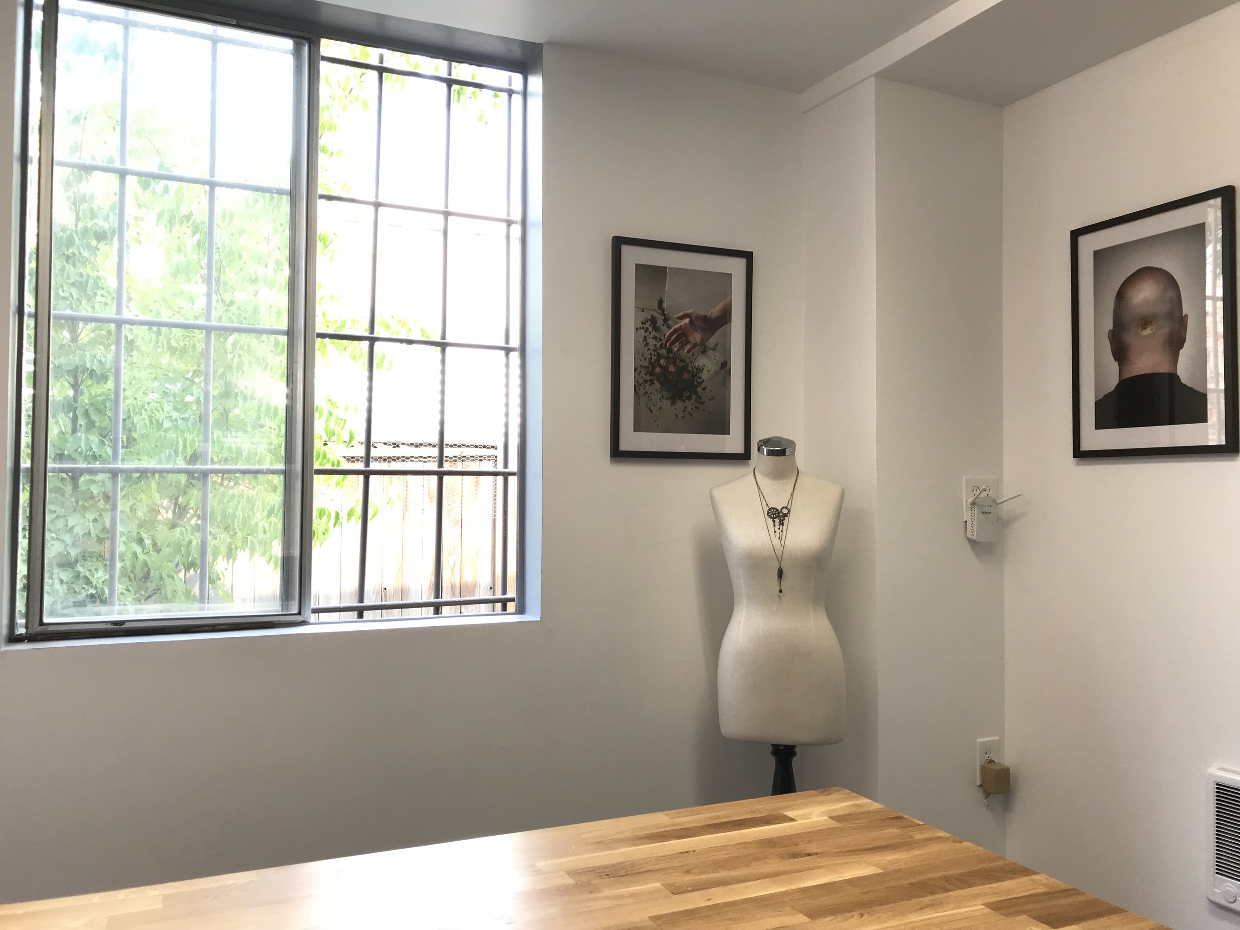 The view from my desk! Not only do I have a great breeze in the summer with 2 open windows, but there's a real grown up heater on that right wall! Plus it's fun to dress up the mannequin with jewels and have a home for some prints from my Lick series.