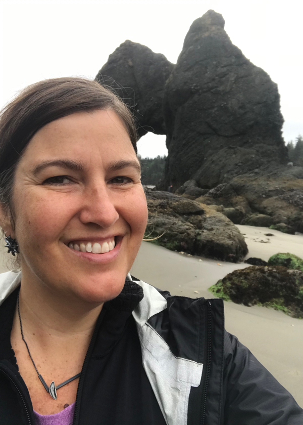 Catherine wearing black silver split bar leaf necklace and sea star post earrings at Point of Arches on Shi Shi Beach in Washington State